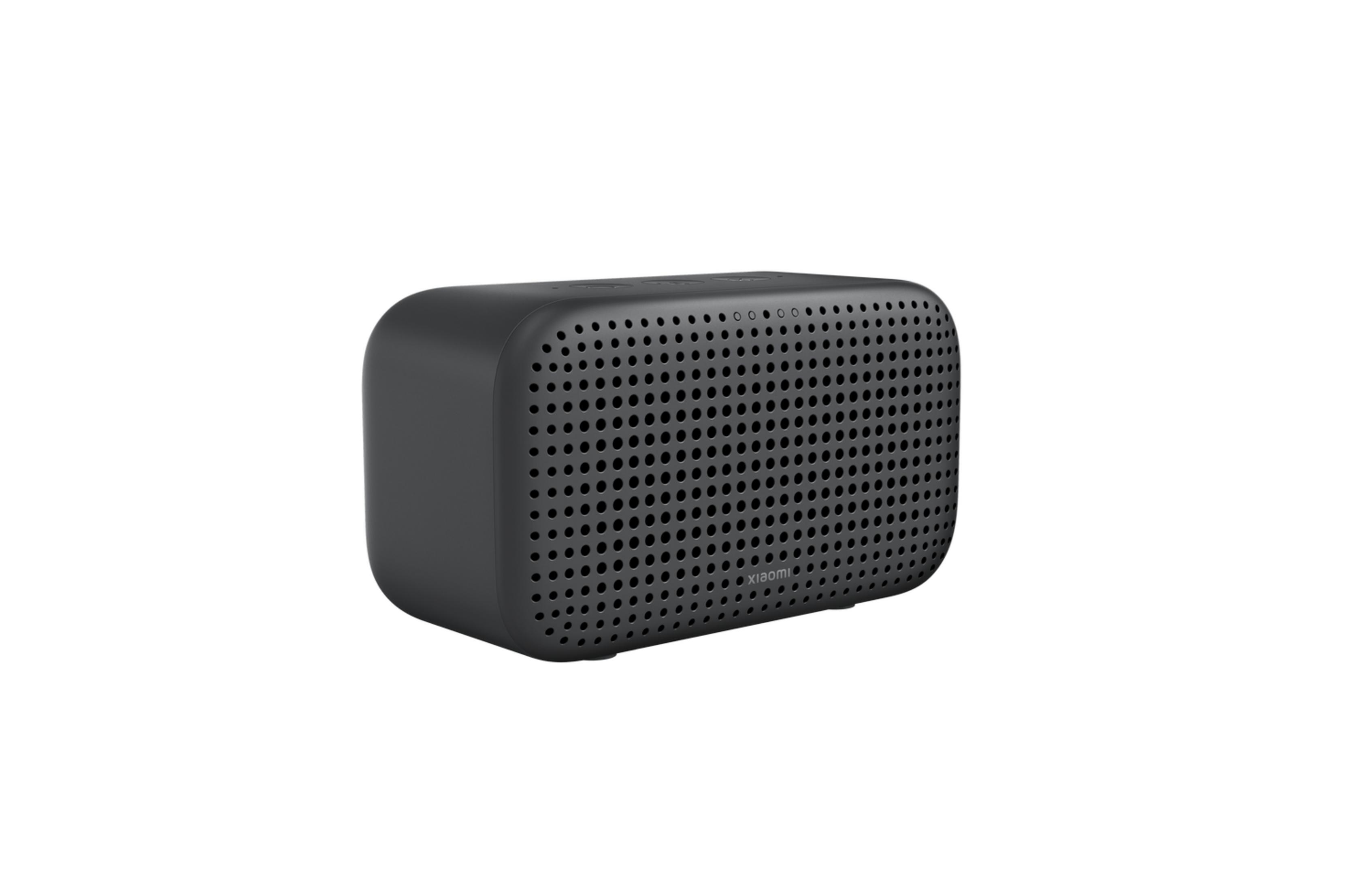 Un altavoz rectangular oscuro con esquinas redondeadas y panel frontal perforado.