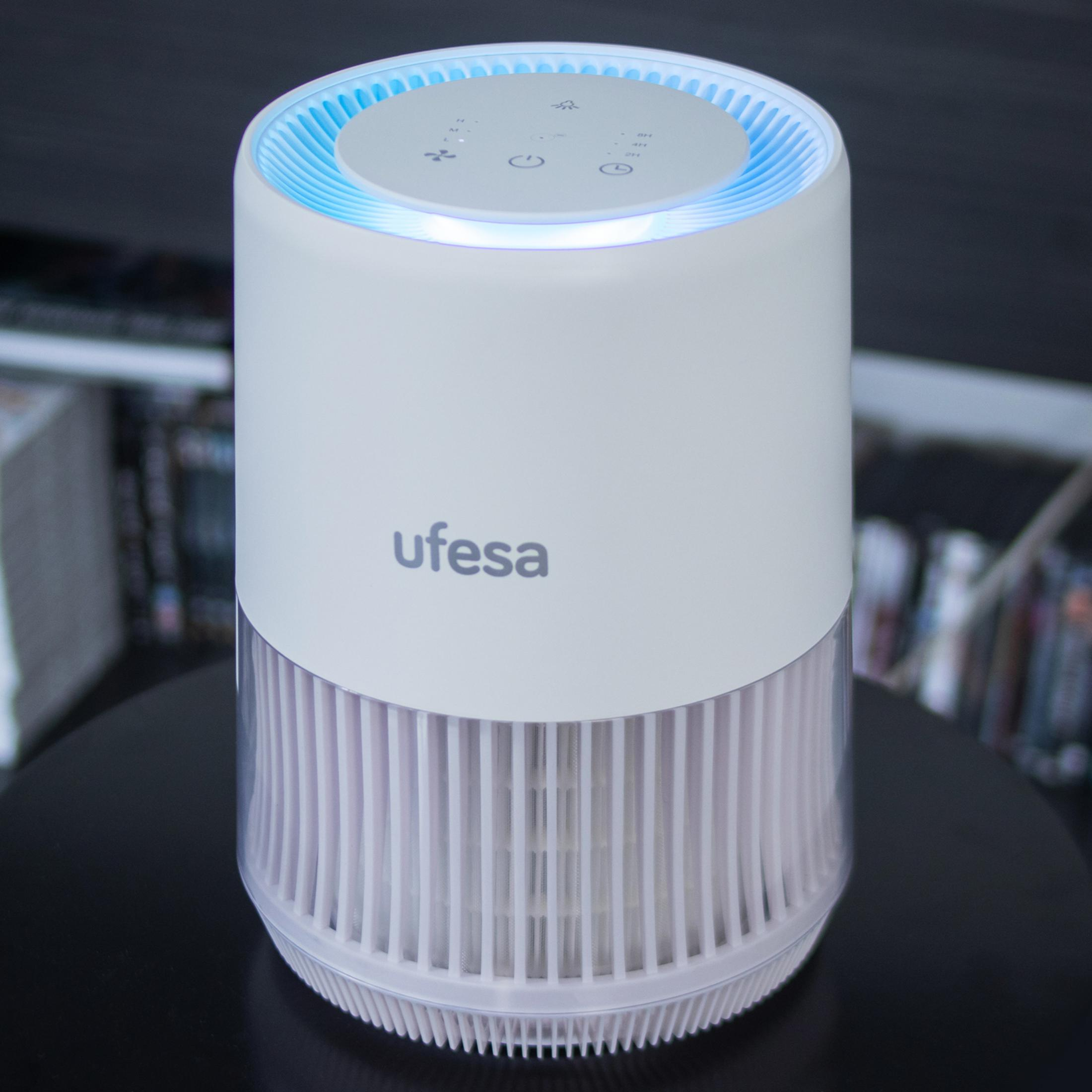 Un purificador de aire blanco con luz azul en la parte superior e iconos de ventilador.