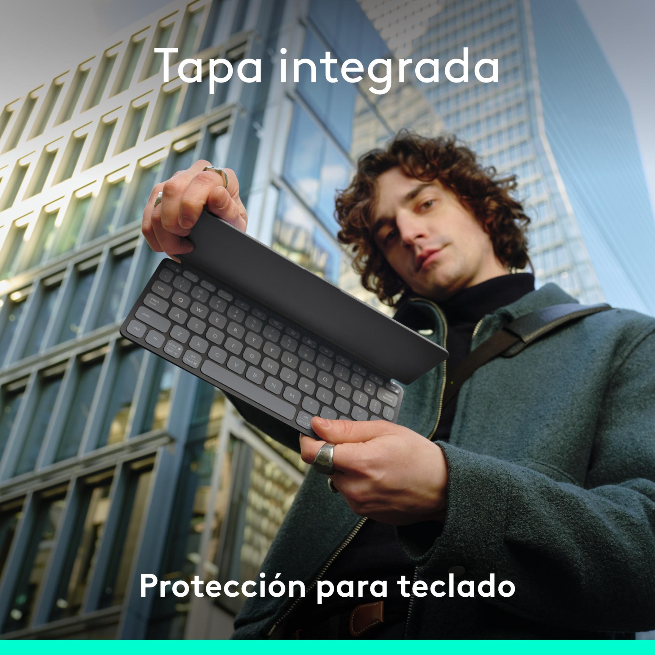 Uomo tiene una cover per tastiera integrata davanti a un edificio moderno.