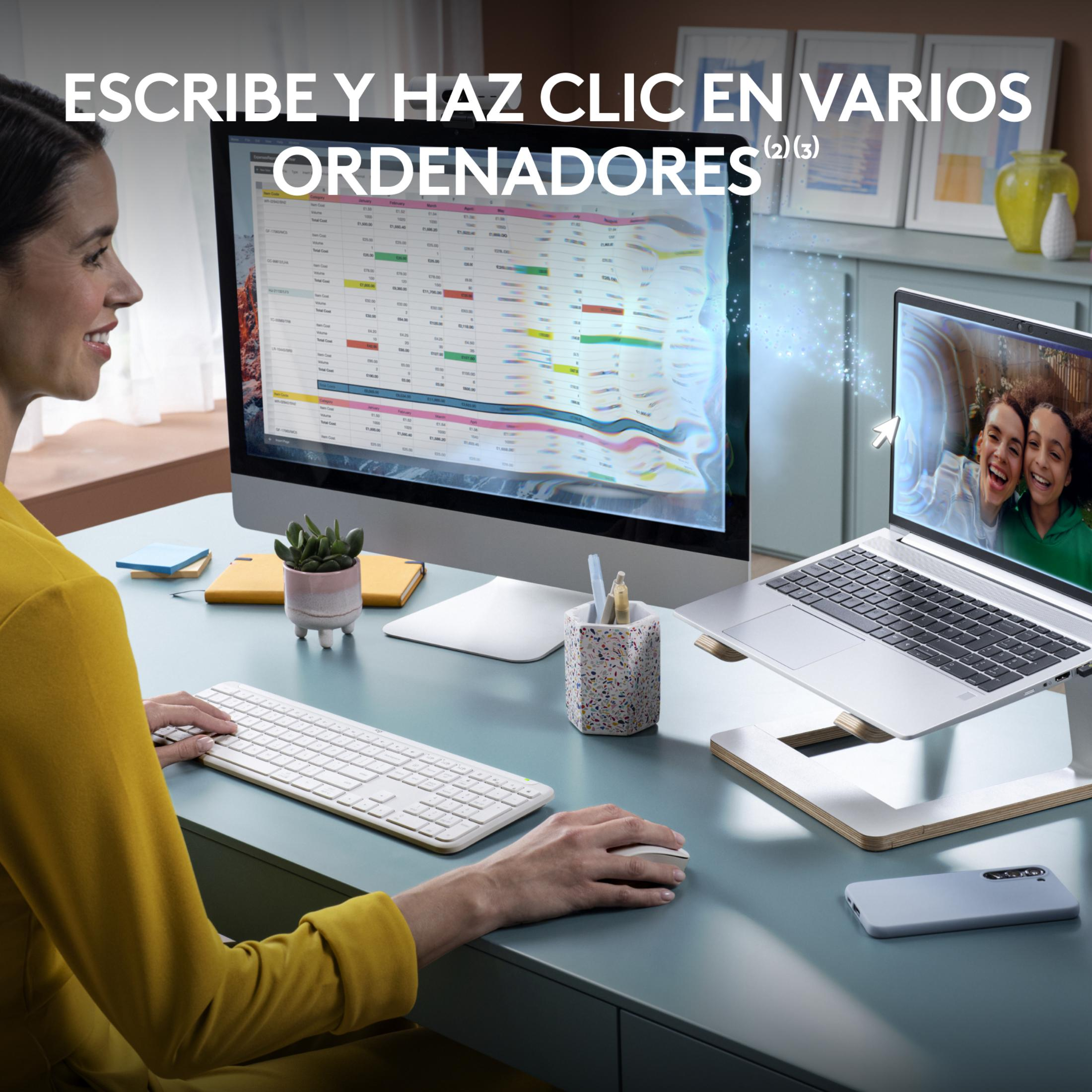 Una donna lavora a una scrivania con due computer e un laptop.