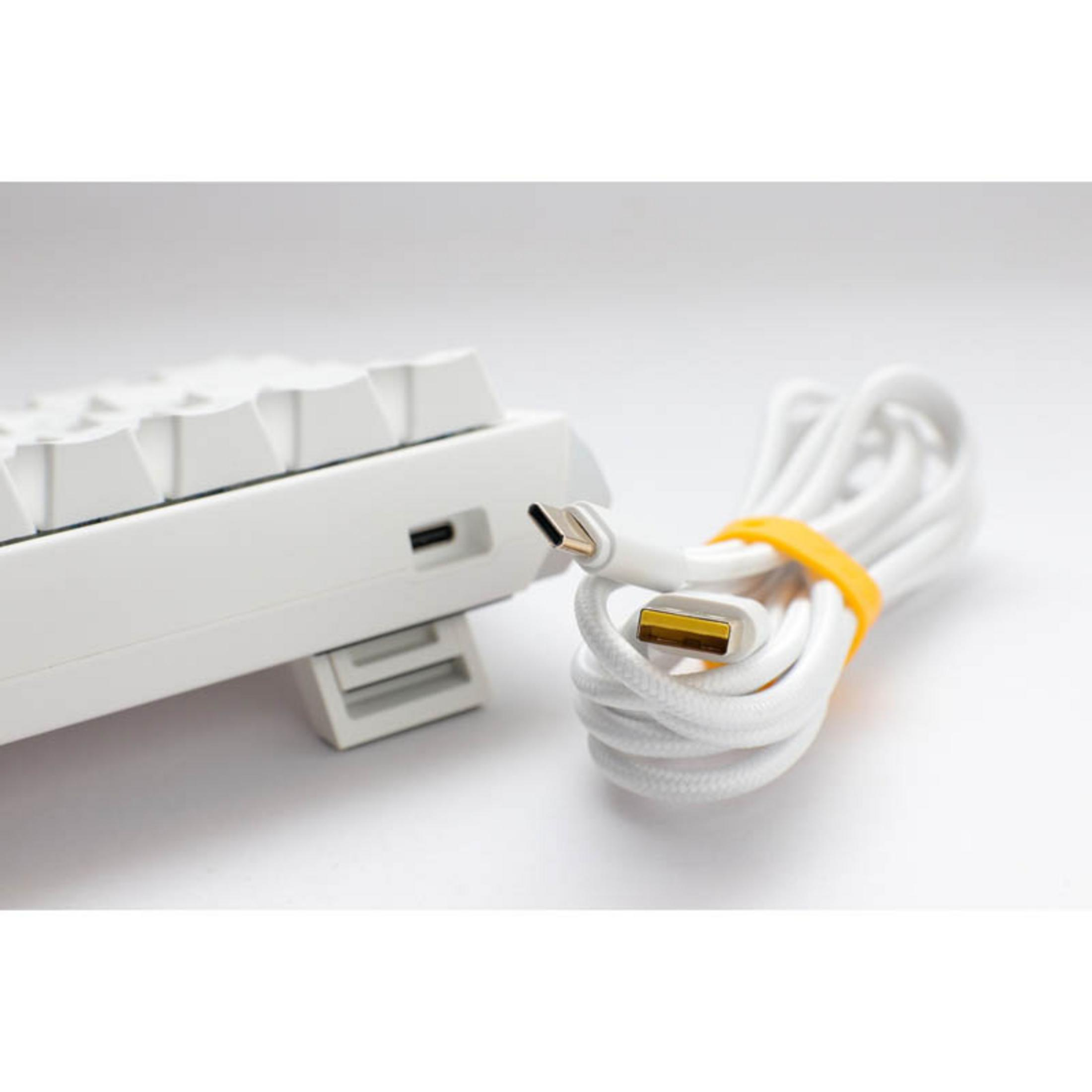Una tastiera bianca con un cavo USB-C bianco, fissato con un elastico arancione.