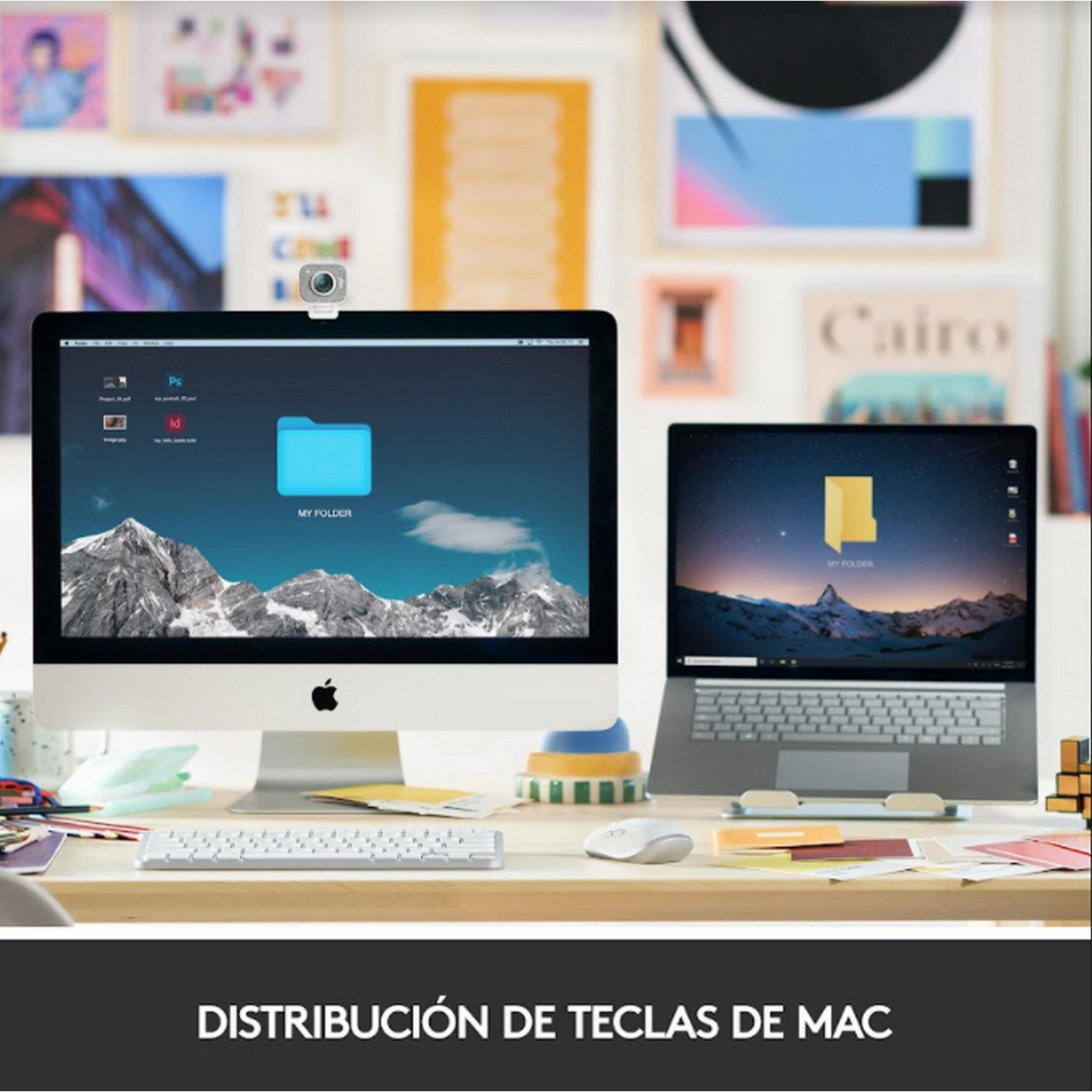 Una scrivania con un iMac, un laptop, tastiere e mouse.