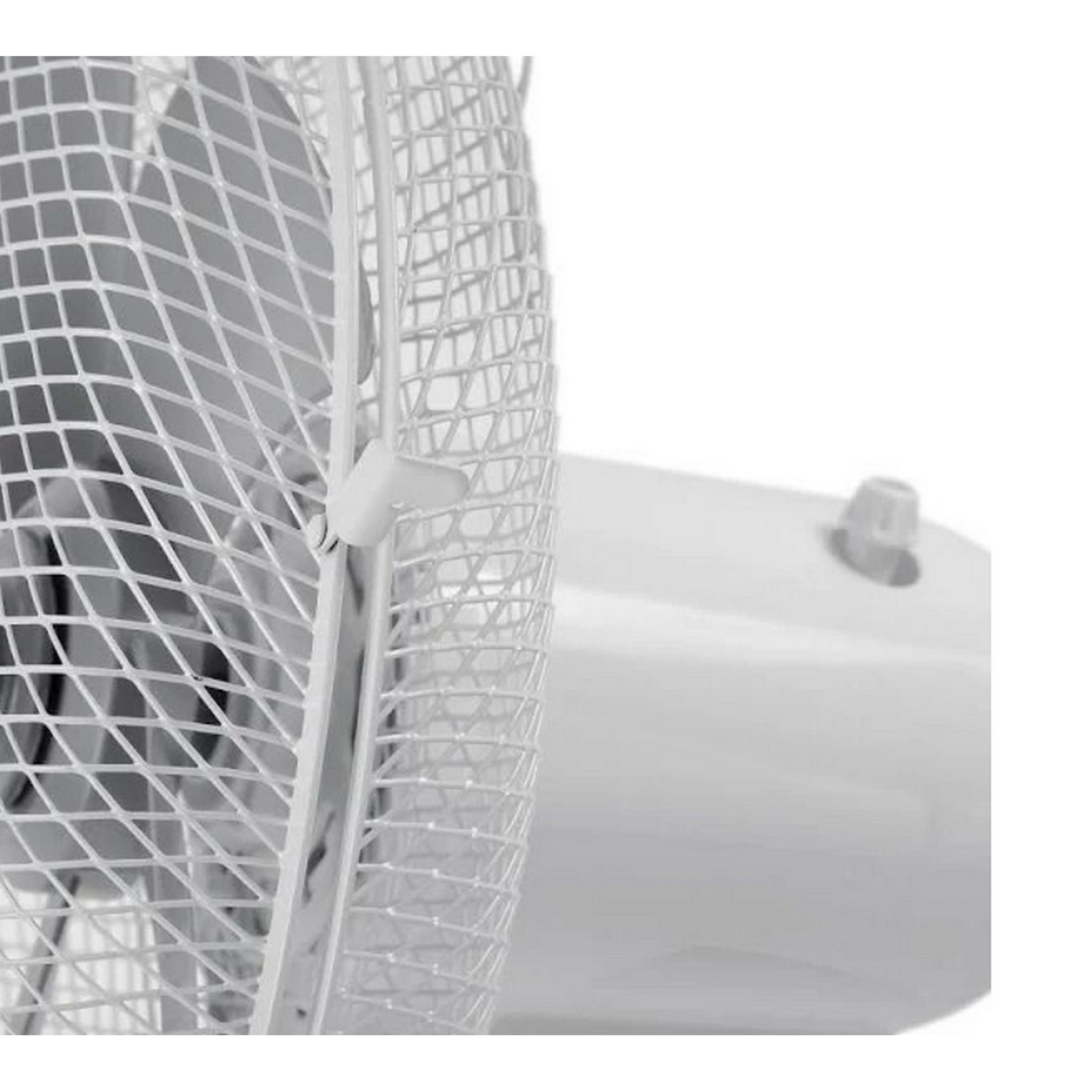 Primer plano de la rejilla blanca de un ventilador con una perilla en la base.