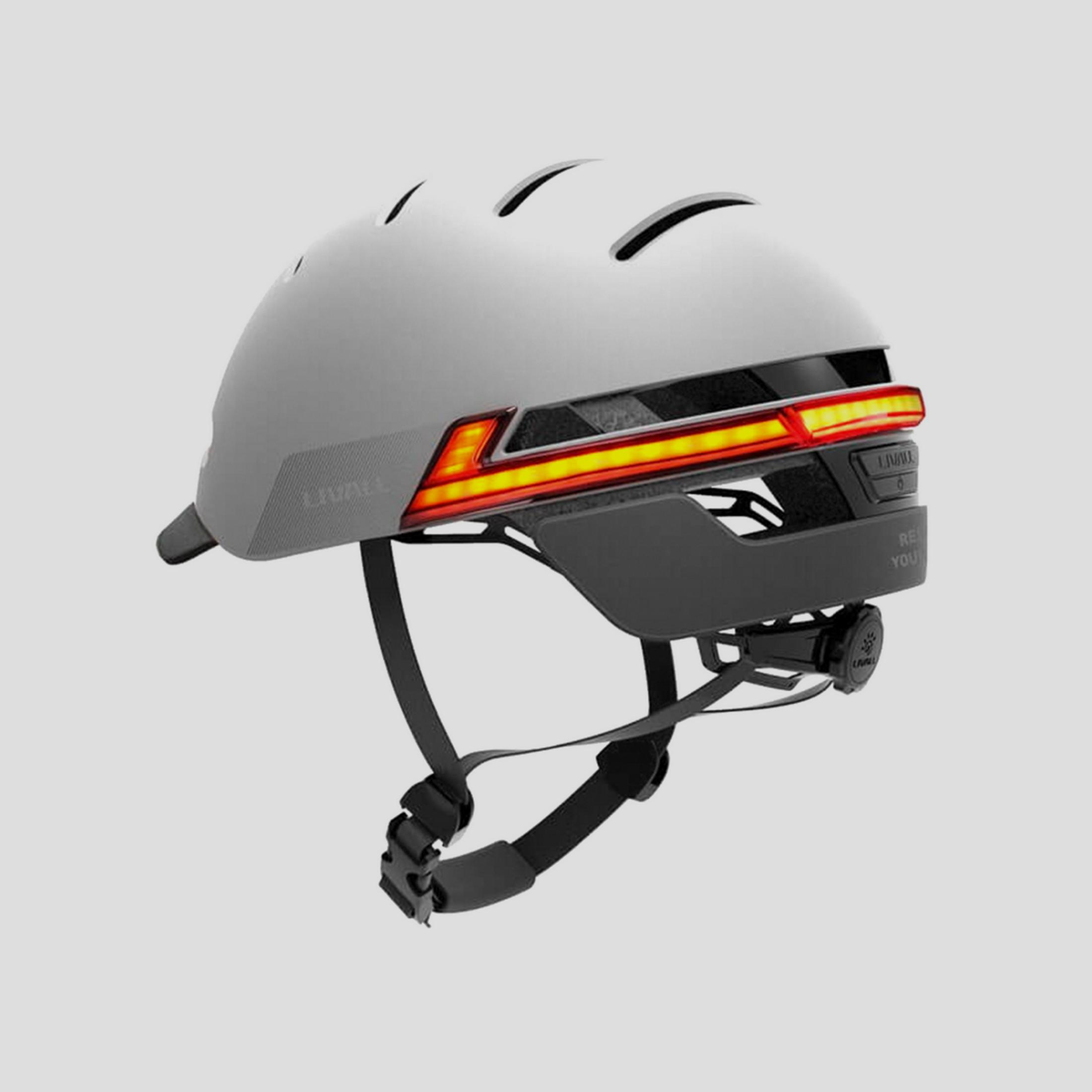 Un casco de bicicleta gris con luz trasera LED roja y amarilla integrada.
