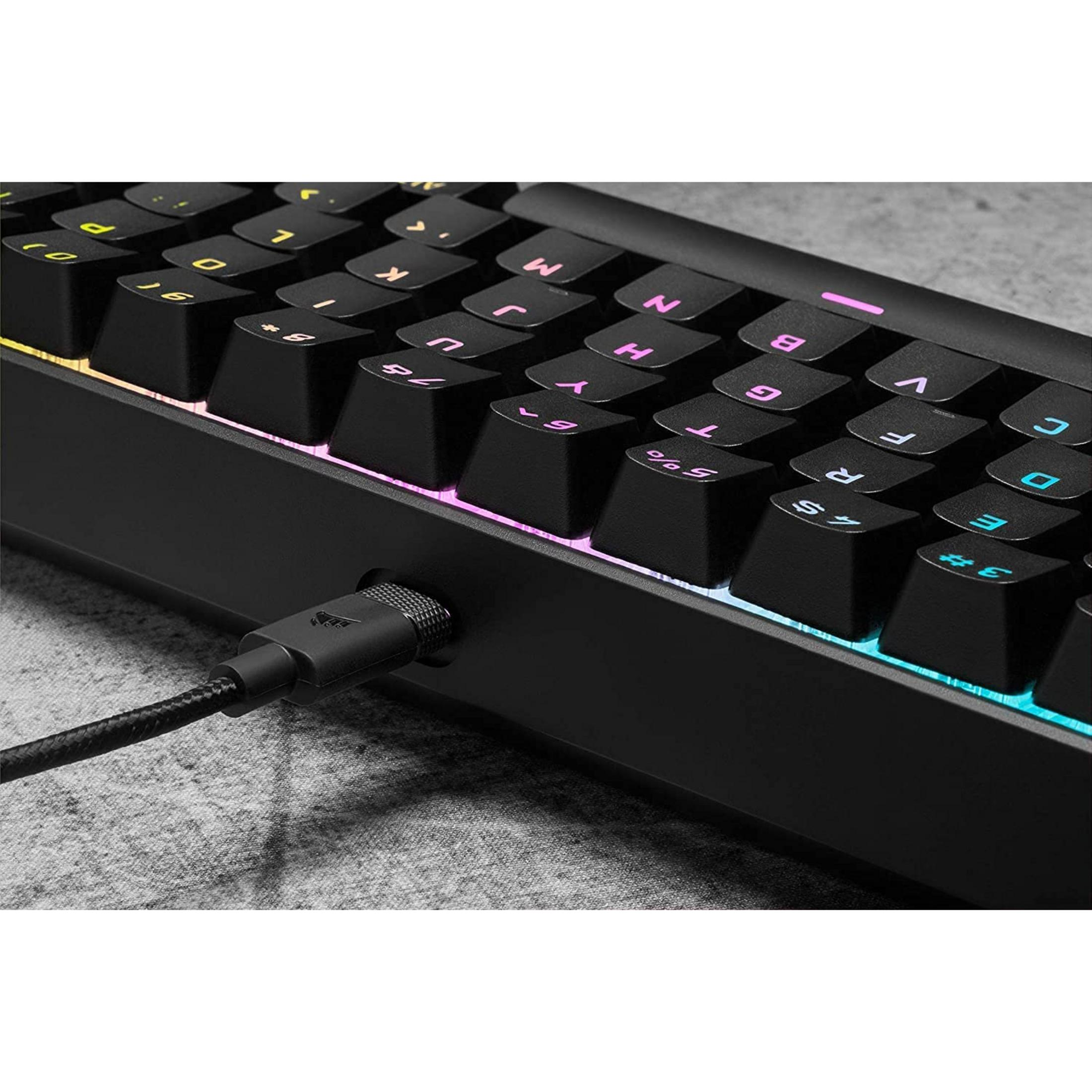 Una tastiera nera con illuminazione RGB e cavo USB collegato.
