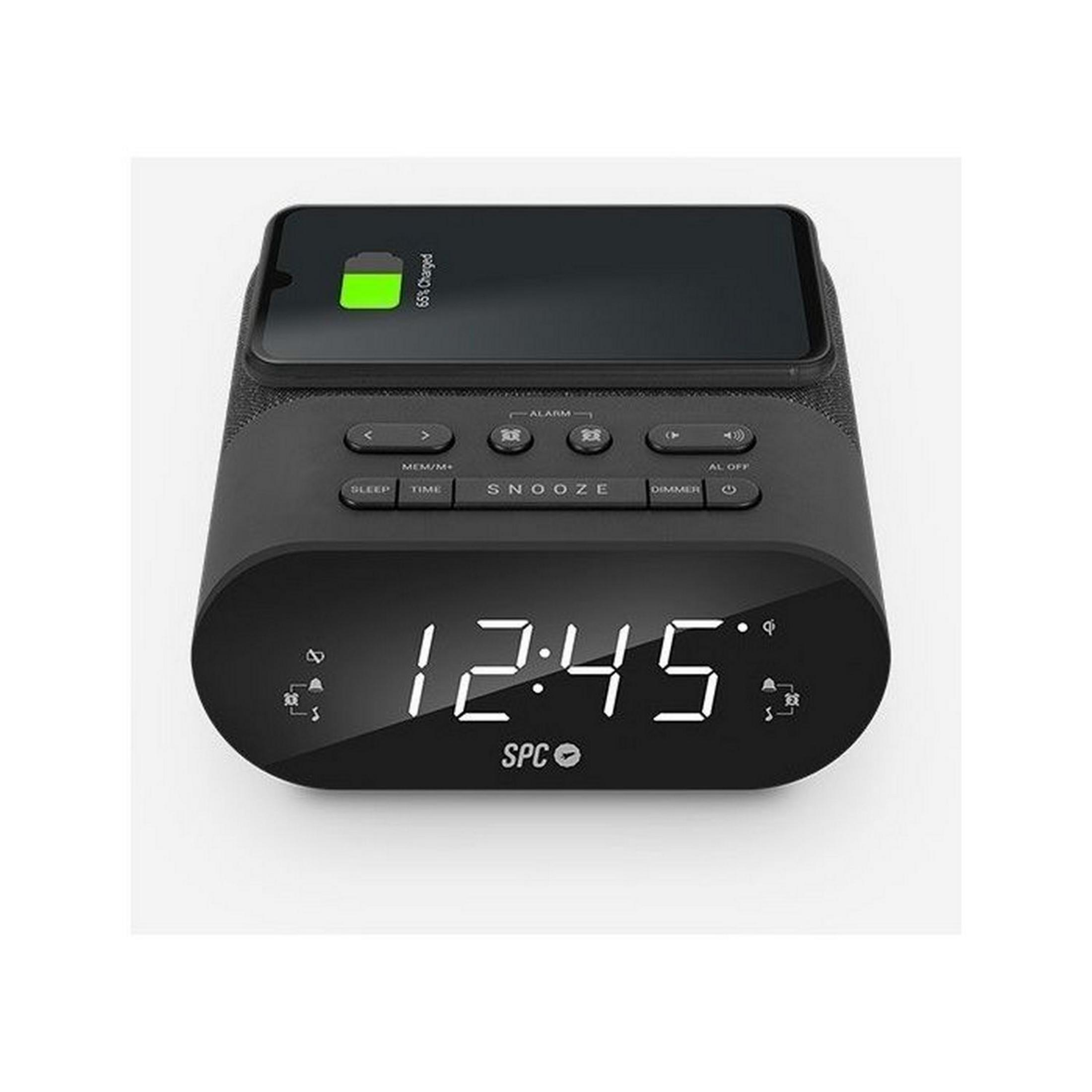 Radio despertador negro con pantalla digital 12:45, cargando móvil 65%.