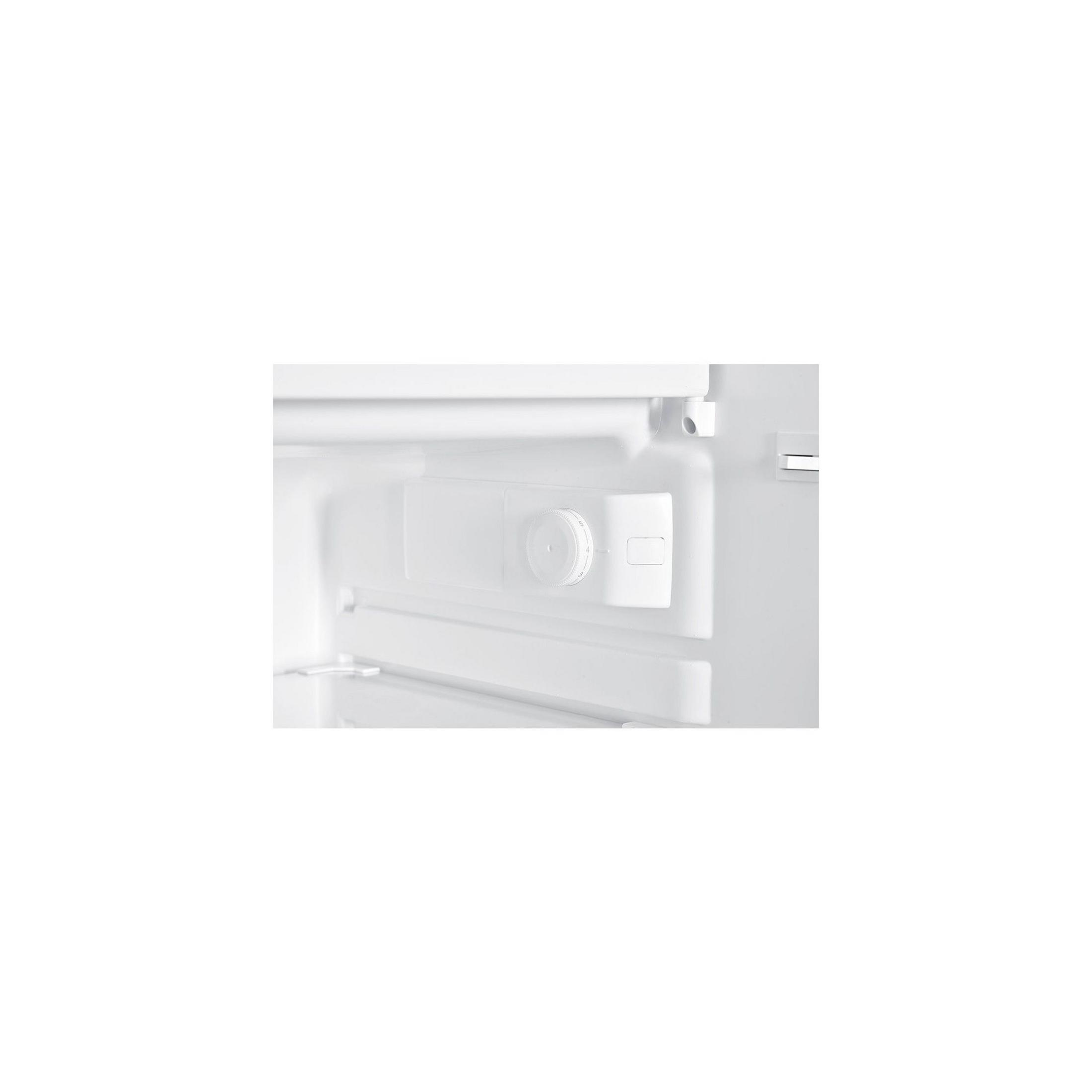 Un dial de temperatura blanco con números del 1 al 5 dentro de un refrigerador.