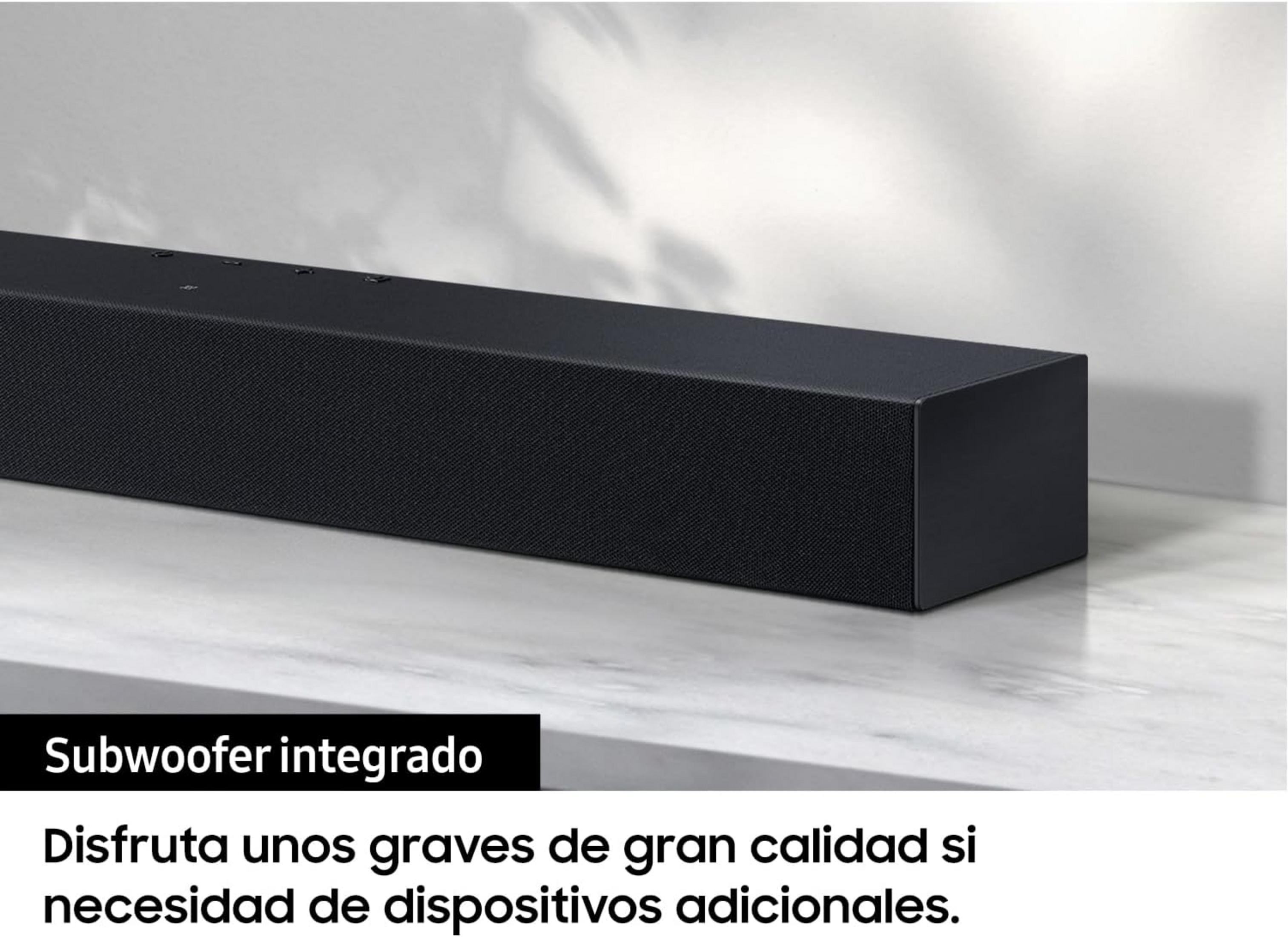 Black subwoofer on marble surface with shadows in the background.