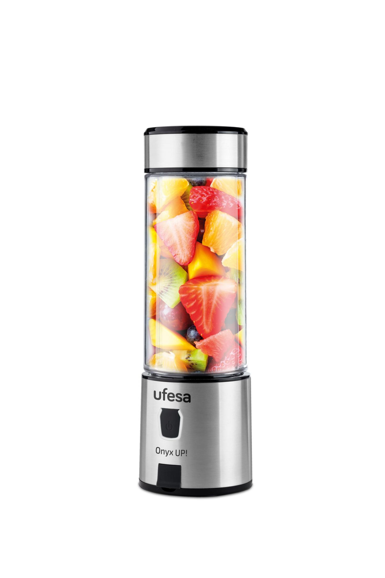 Una licuadora llena de fresas, kiwi, piña y arándanos.