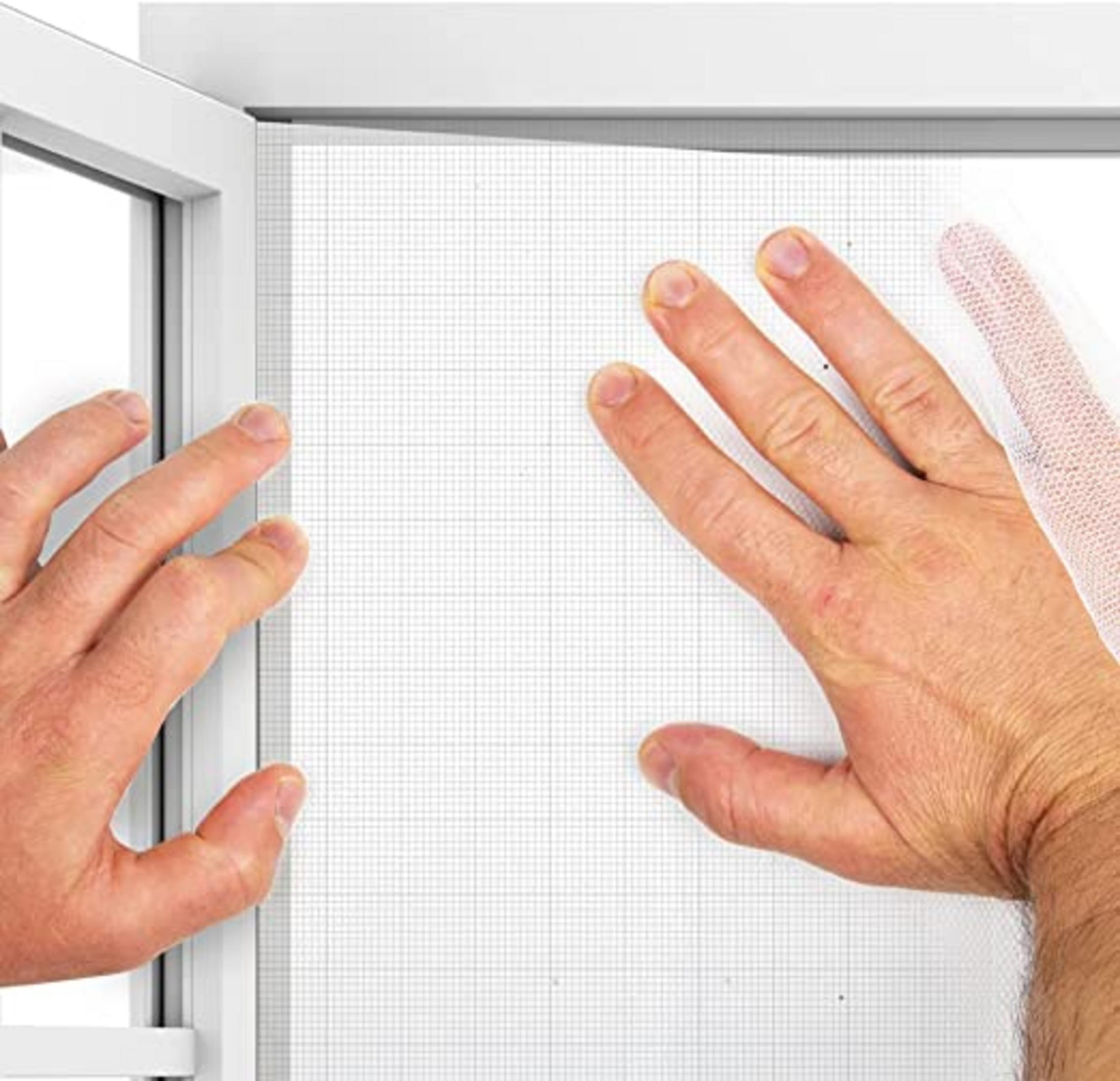 Manos tocando una rejilla blanca en un marco de ventana.