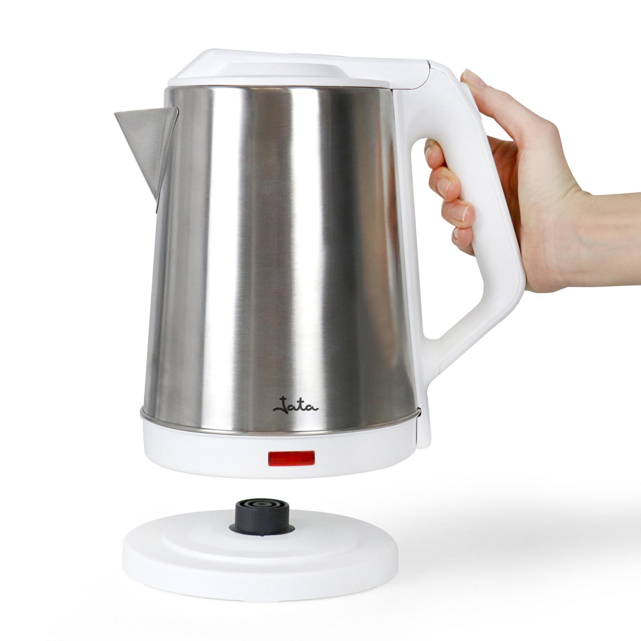 Una mano sostiene una tetera de acero inoxidable con asa y base blancas.