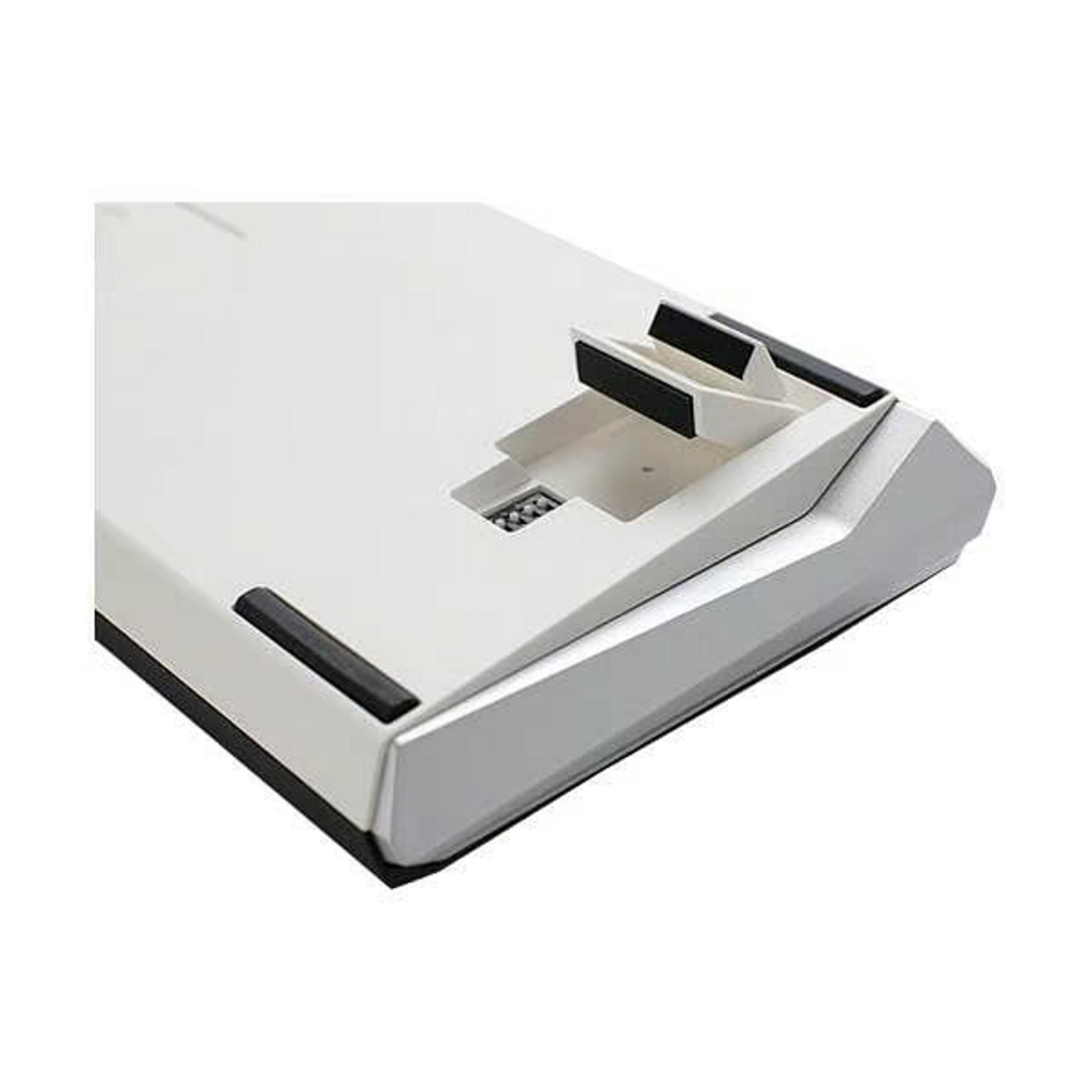 Parte inferiore di una tastiera bianca con accenti argentati e piedini in gomma. Porta USB-C.
