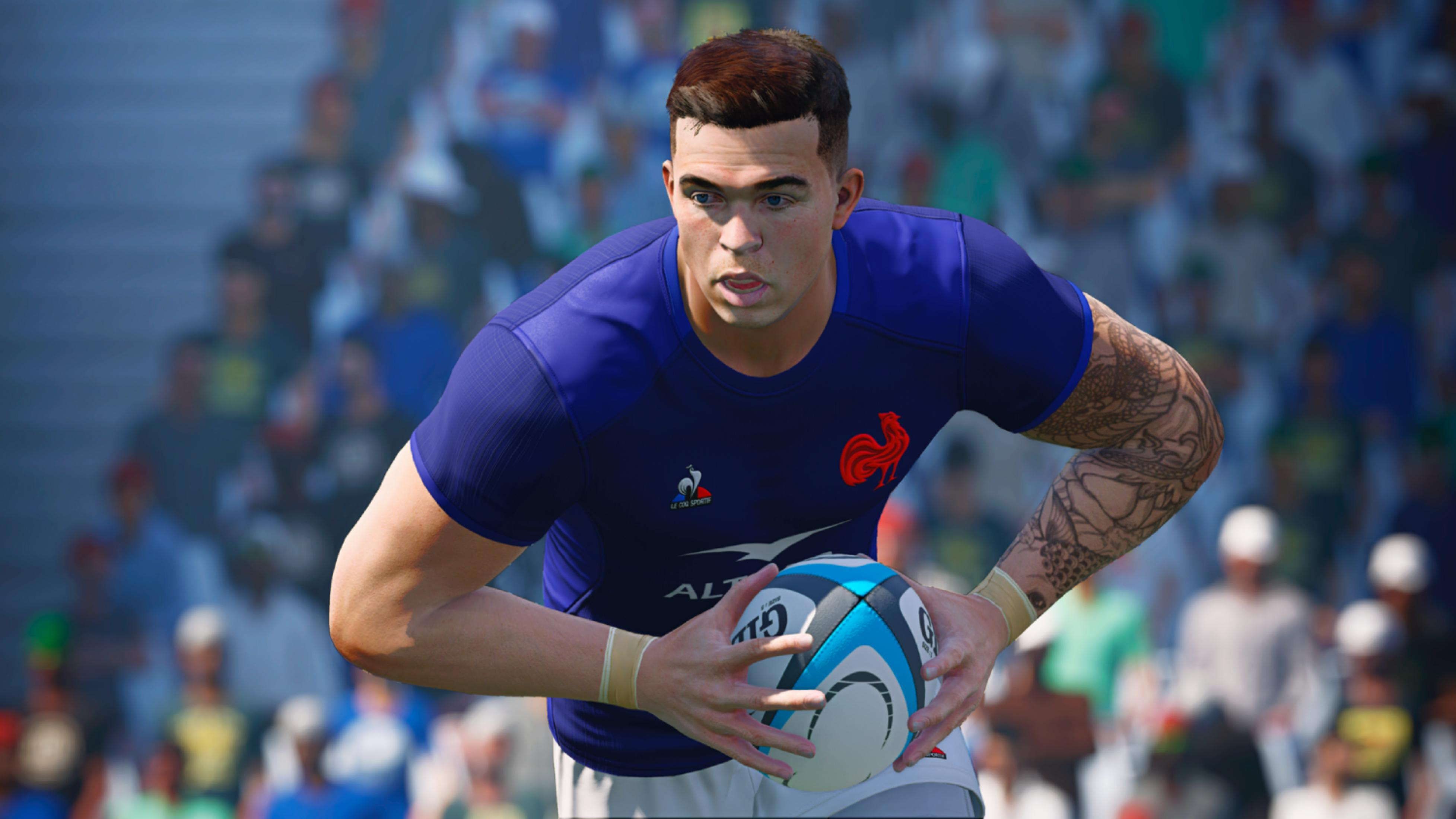 Jugador de rugby con camiseta azul y gallo rojo sostiene un balón. Tatuaje en el brazo.
