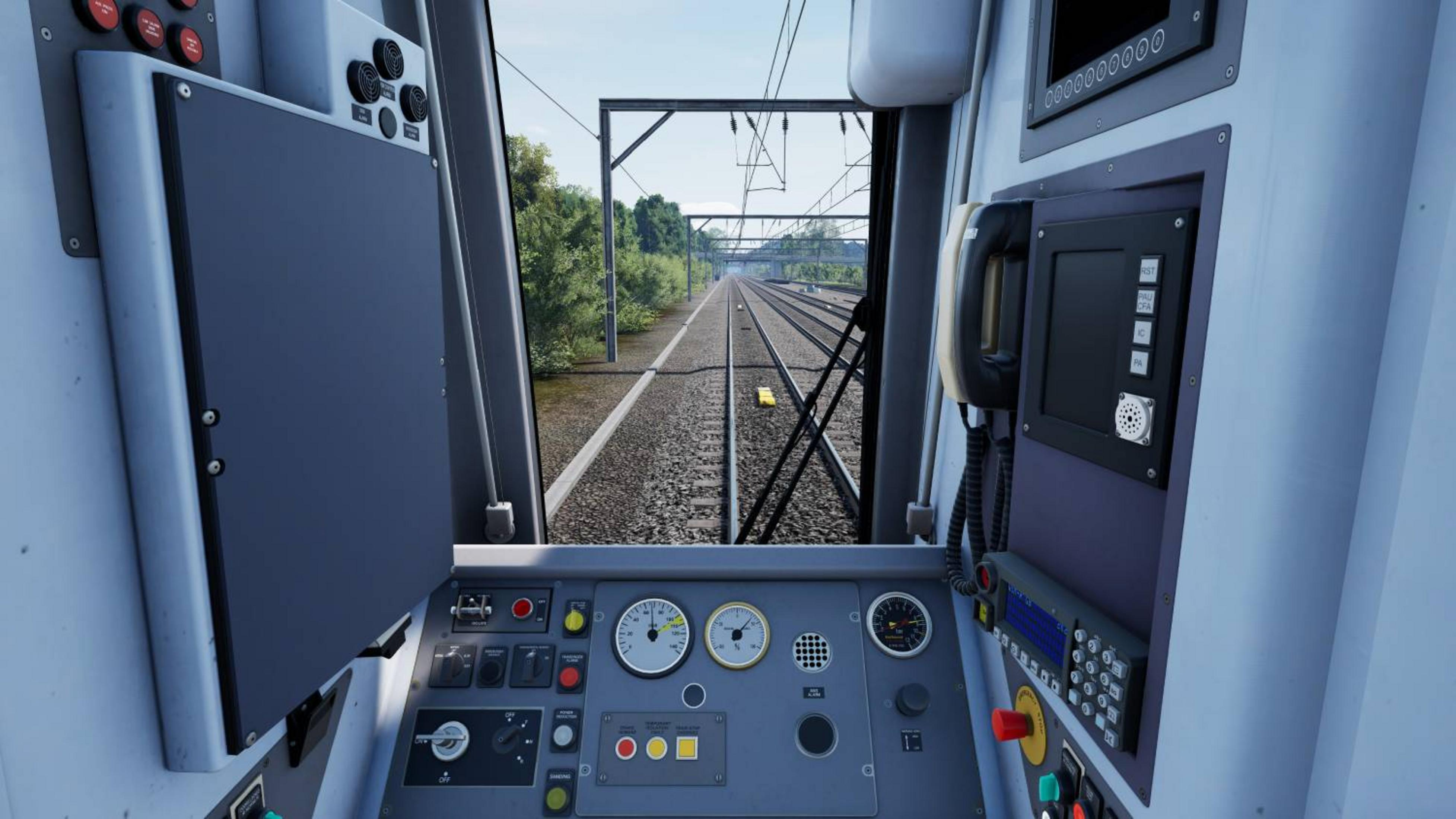 Vista dalla cabina di un treno sui binari con linee aeree, alberi e cielo.