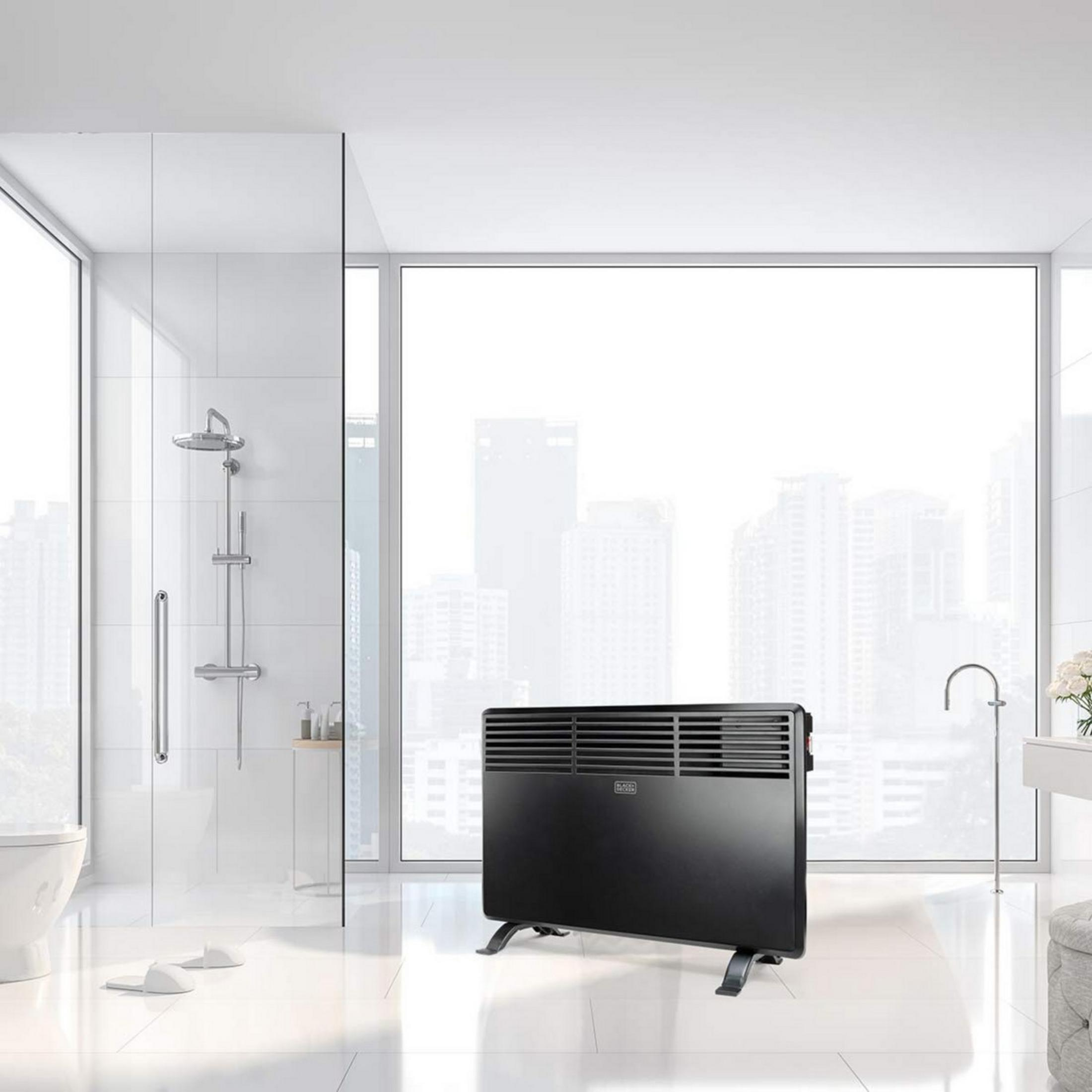Un radiatore nero in un bagno moderno e luminoso con una grande finestra.