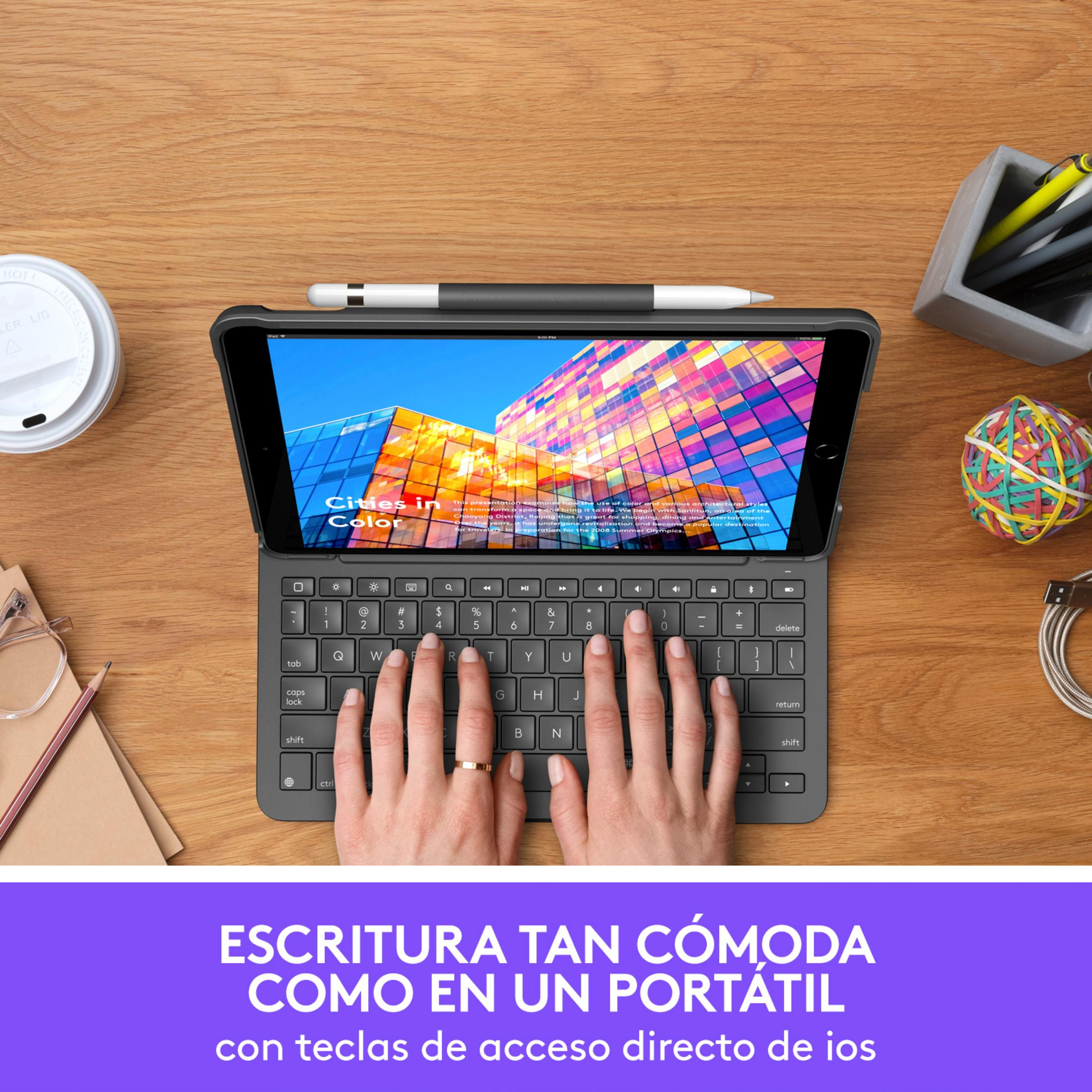 Un iPad con teclado y lápiz sobre un escritorio de madera, con una taza y material de oficina.