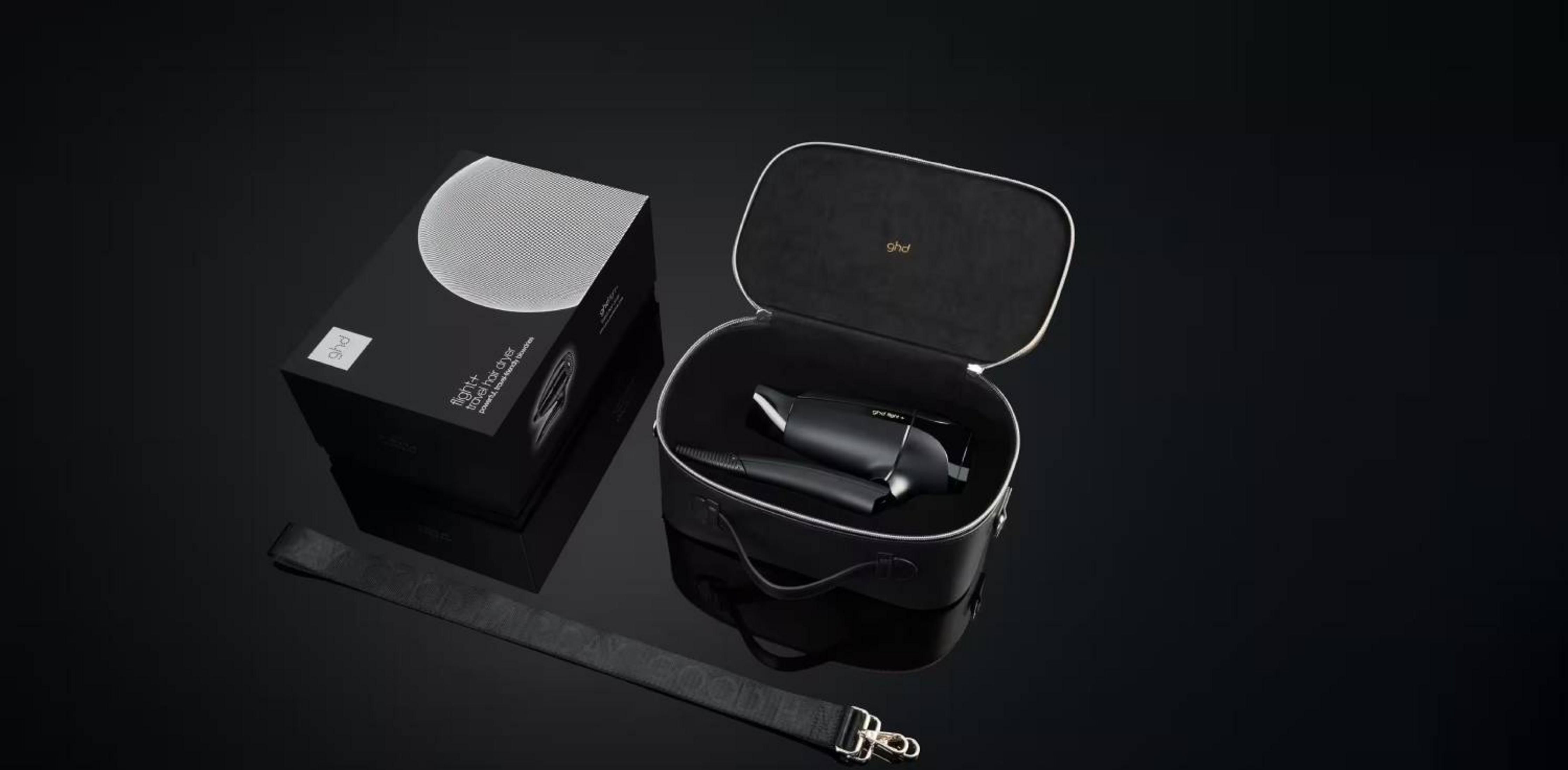 Secador de pelo de viaje negro en un estuche abierto junto a su caja.