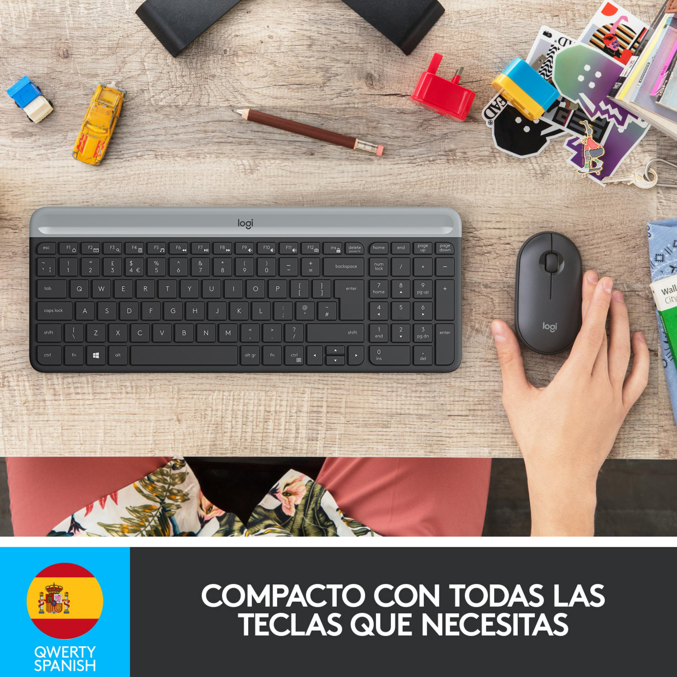 Una tastiera e un mouse Logitech grigi su una scrivania di legno con macchinine.