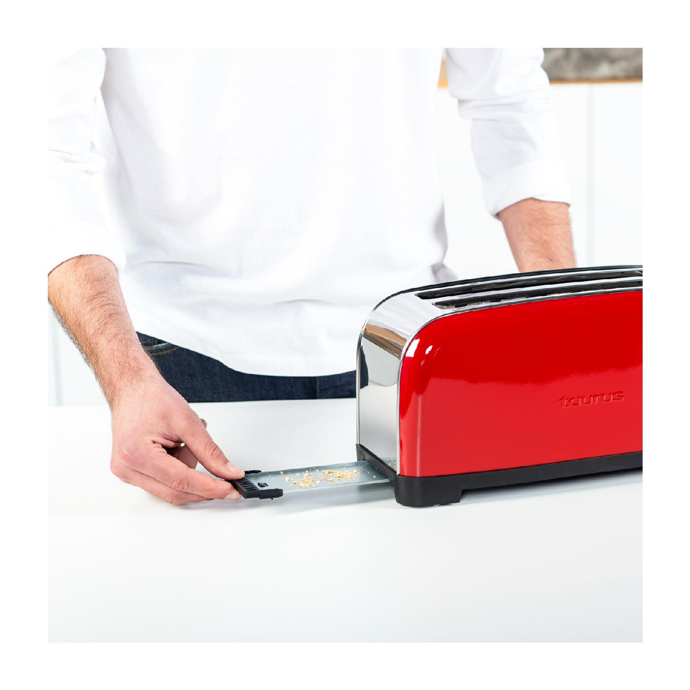Ein Mann mit weißem Hemd zieht eine Krümelschublade aus einem roten Toaster.