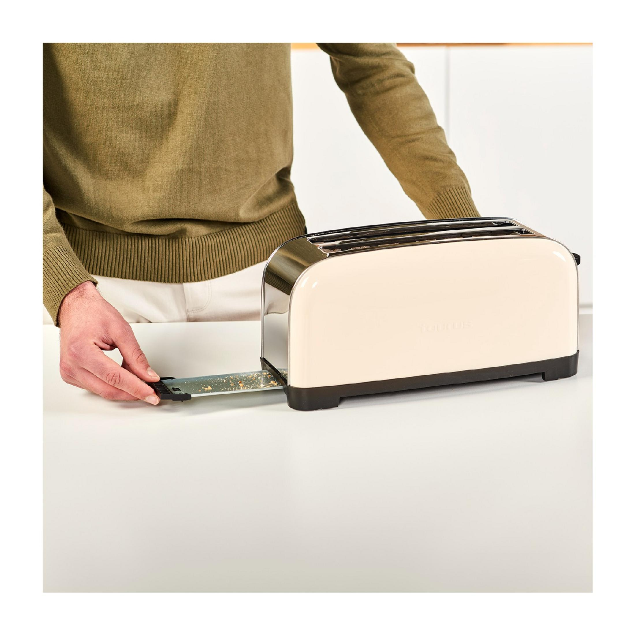 Una mano inserisce una fessura per tostapane in un tostapane color crema.