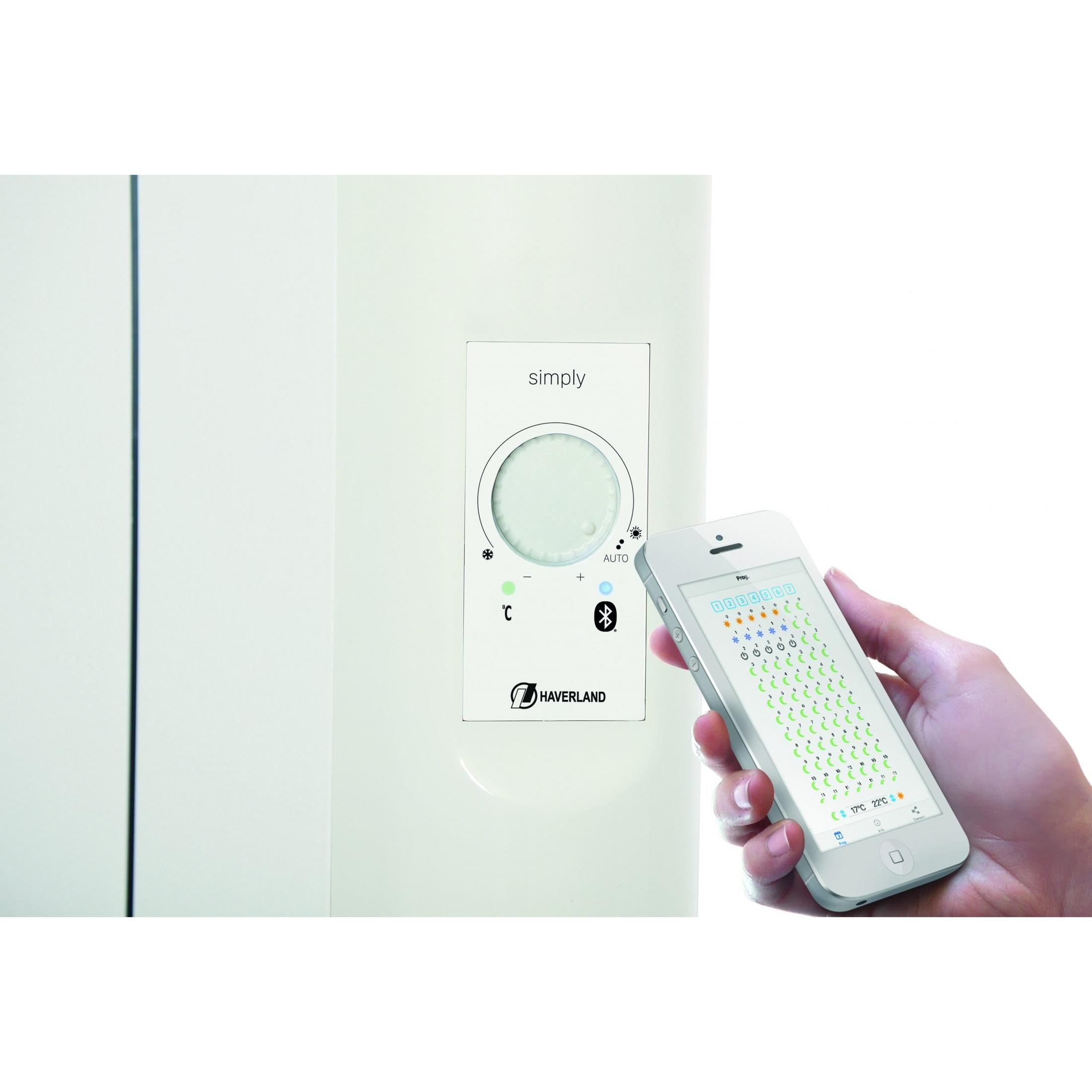 Un smartphone muestra un control de calefacción, junto a un termostato.