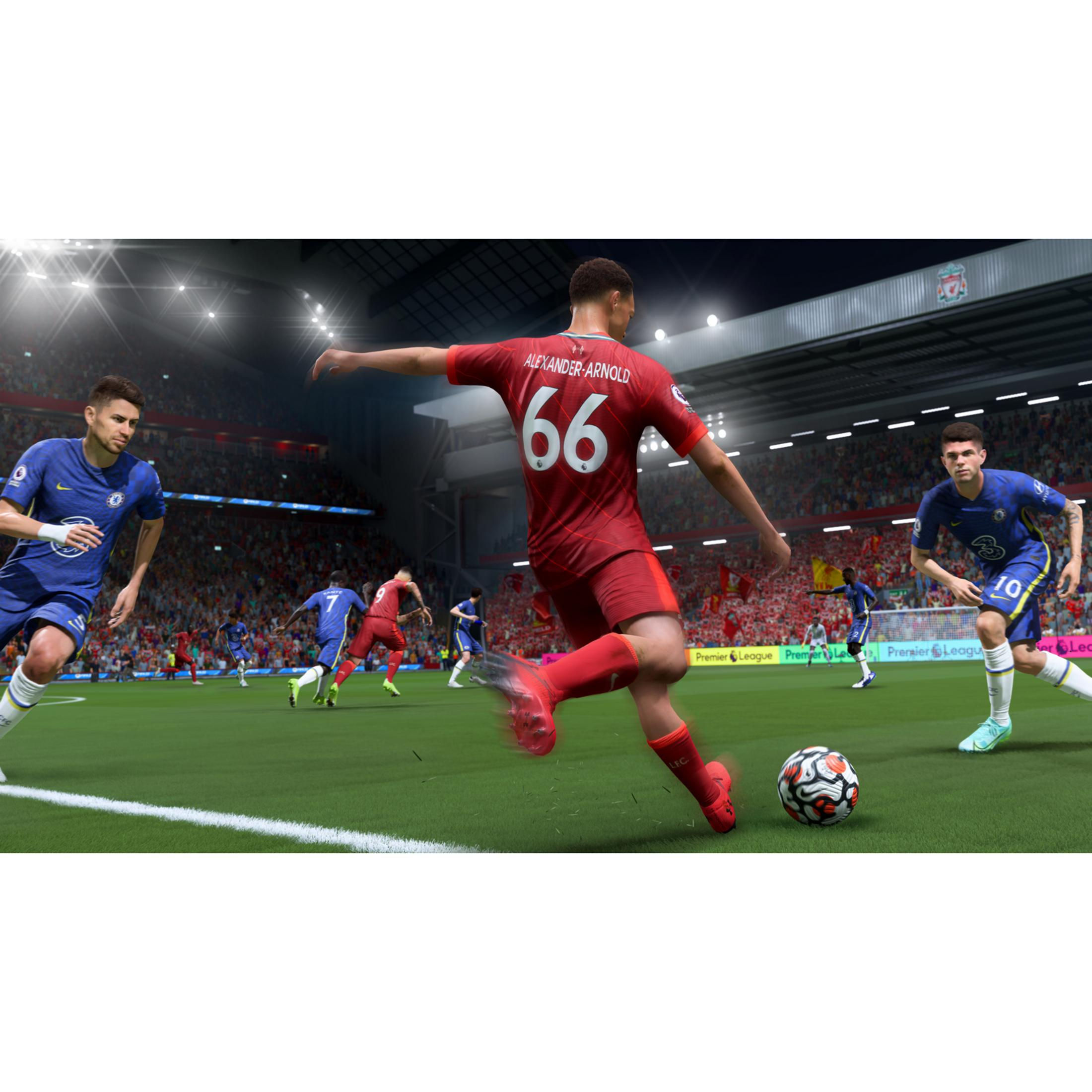 Partido de fútbol en estadio de noche, jugadores con camisetas rojas y azules en césped verde.