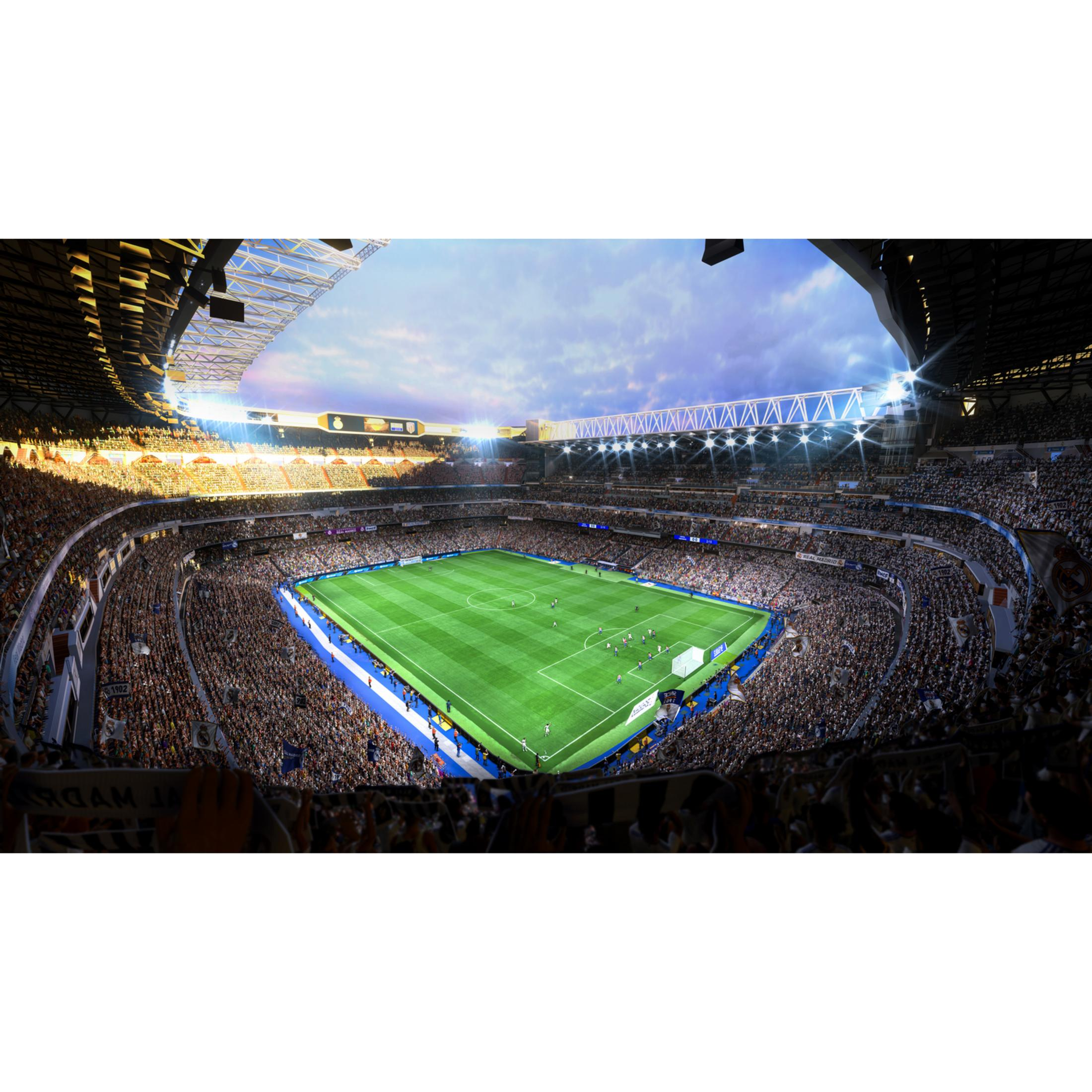 Un estadio de fútbol lleno de espectadores por la noche. El campo es verde y está bien iluminado.