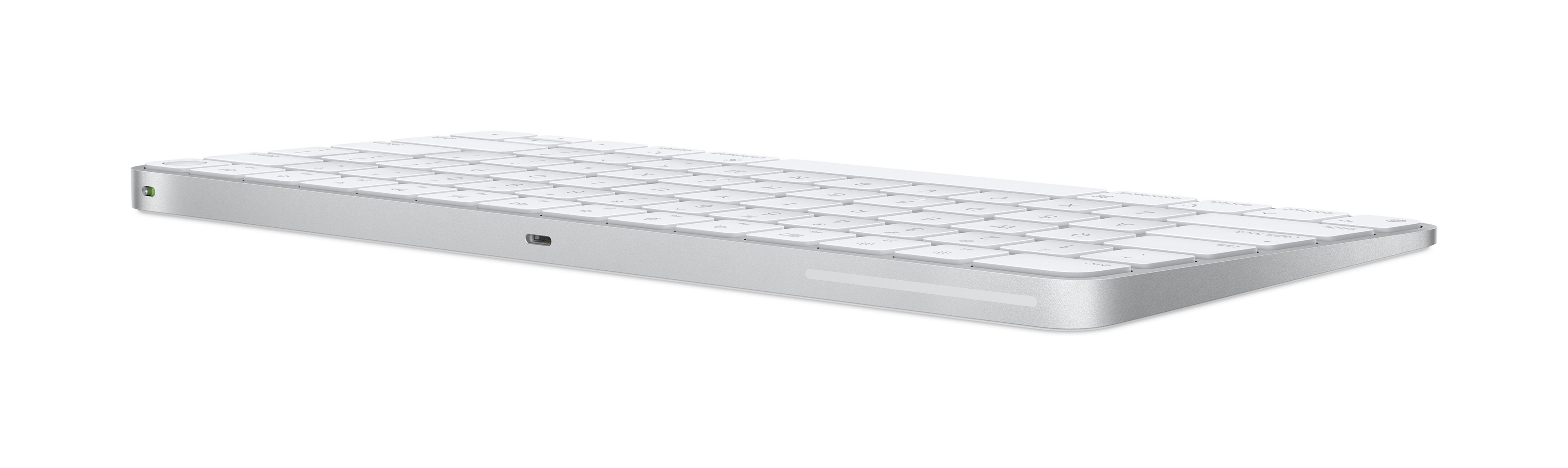 Un teclado plateado con teclas blancas descansa sobre un fondo blanco.