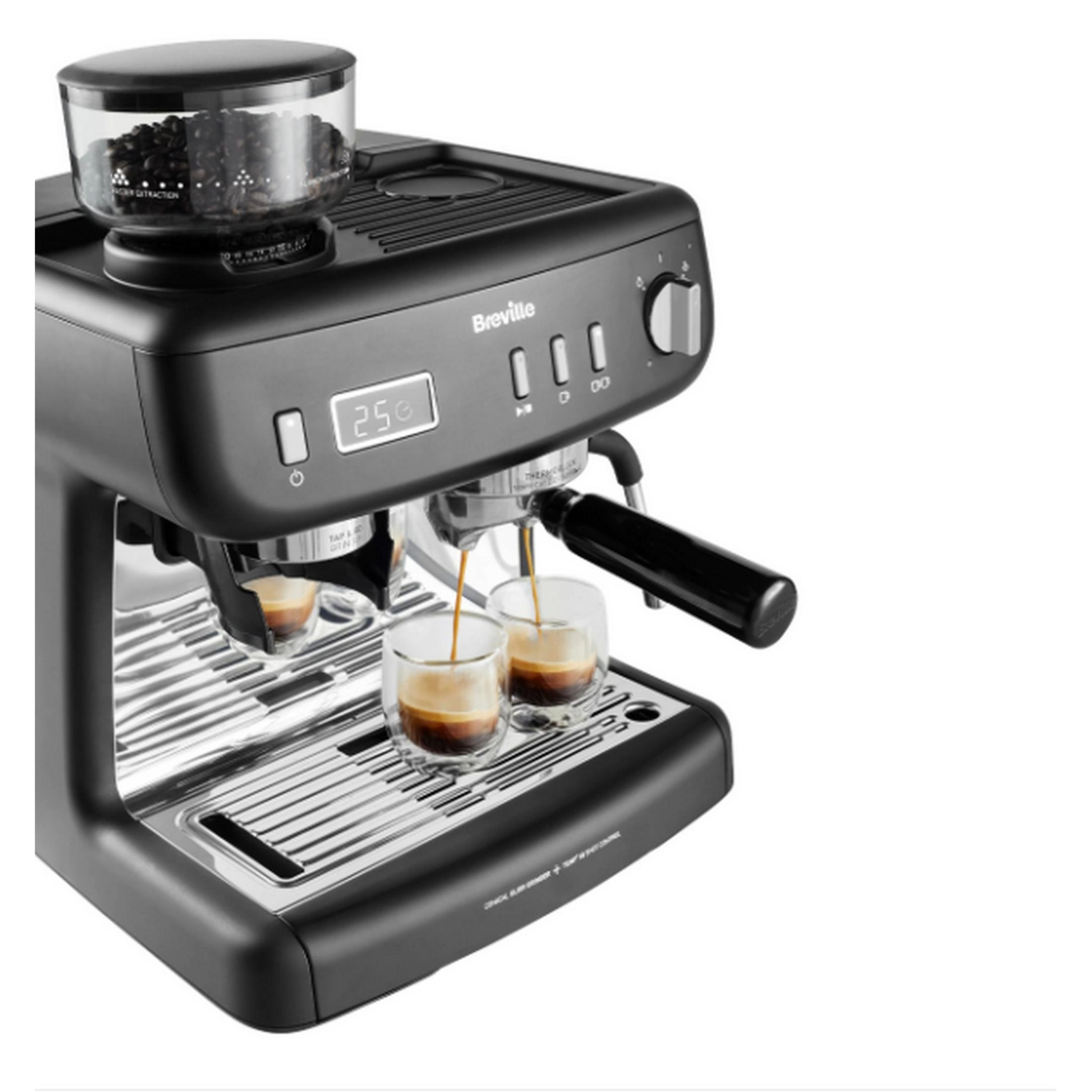 Una máquina de espresso negra prepara dos cafés expresos en vasos pequeños.