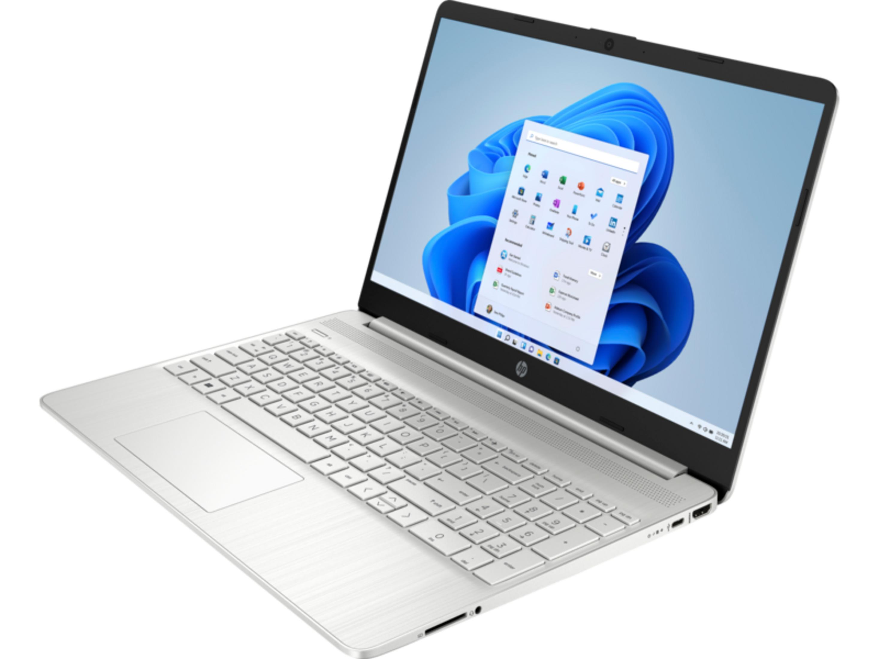 Un portátil plateado con pantalla abierta que muestra el menú de inicio de Windows 11.