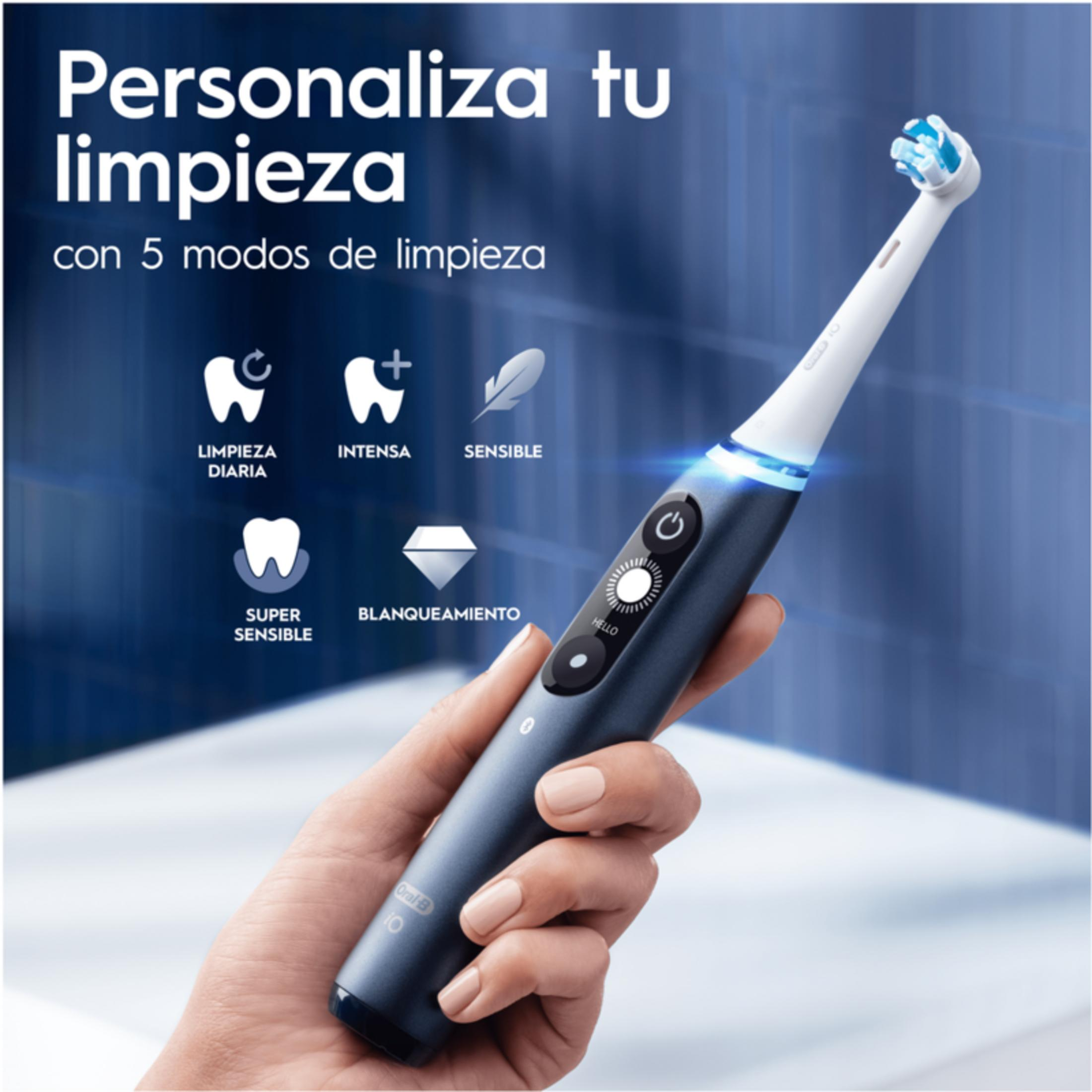 Una mano sostiene un cepillo de dientes eléctrico con cerdas azules y detalles brillantes.