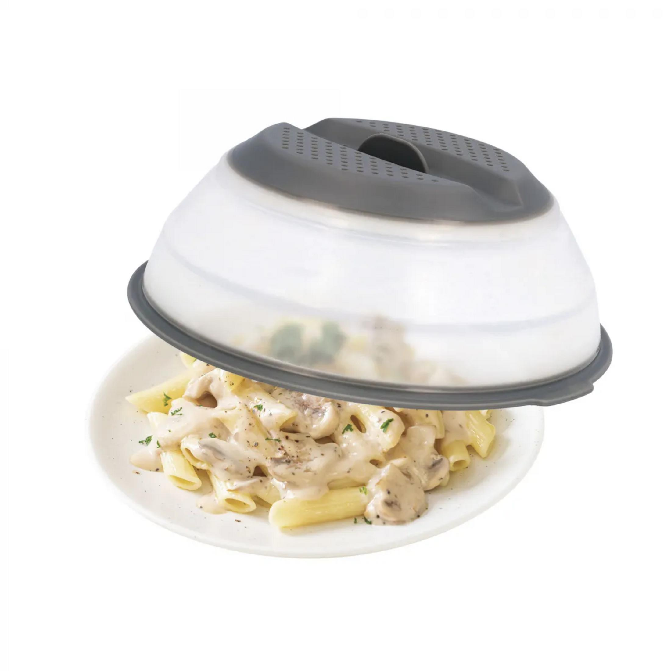 Un plato blanco de pasta penne con salsa cremosa de champiñones, cubierto por una tapa ventilada gris.