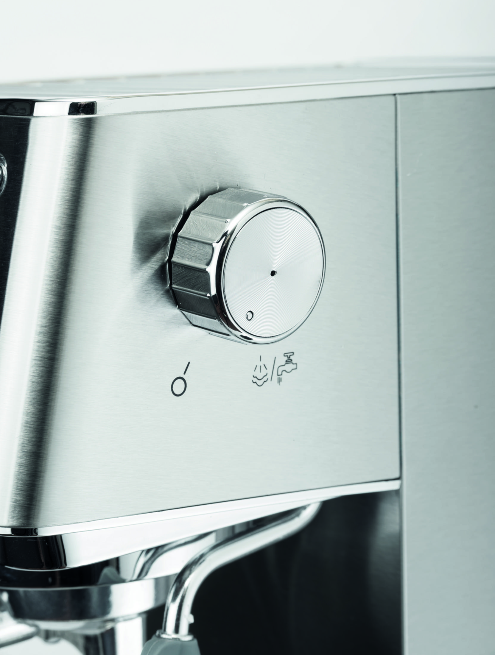 Primo piano di una macchina per espresso argentata con manopola e simboli vapore/acqua.