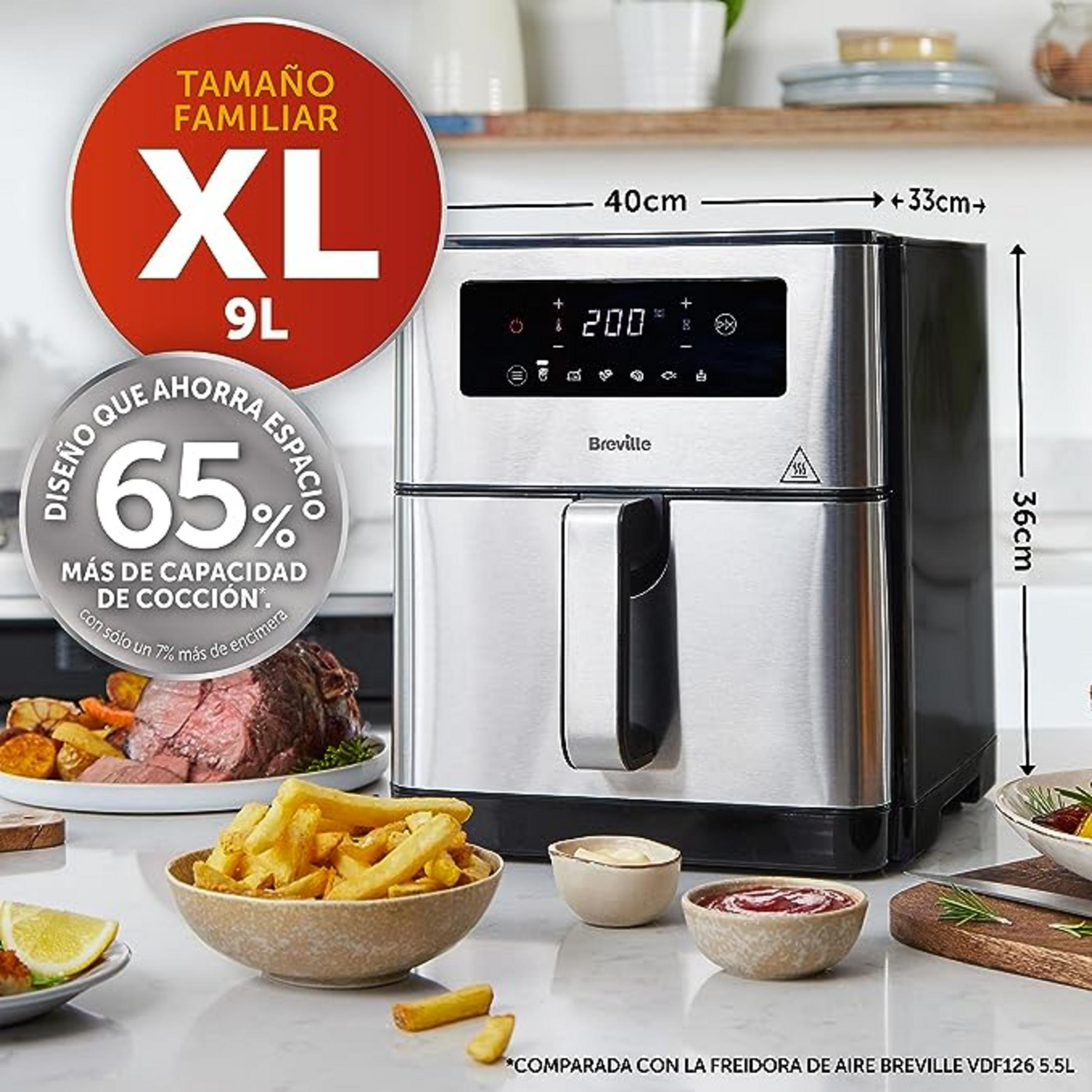 Freidora de aire de acero inoxidable con pantalla, junto a comida como asado y papas.