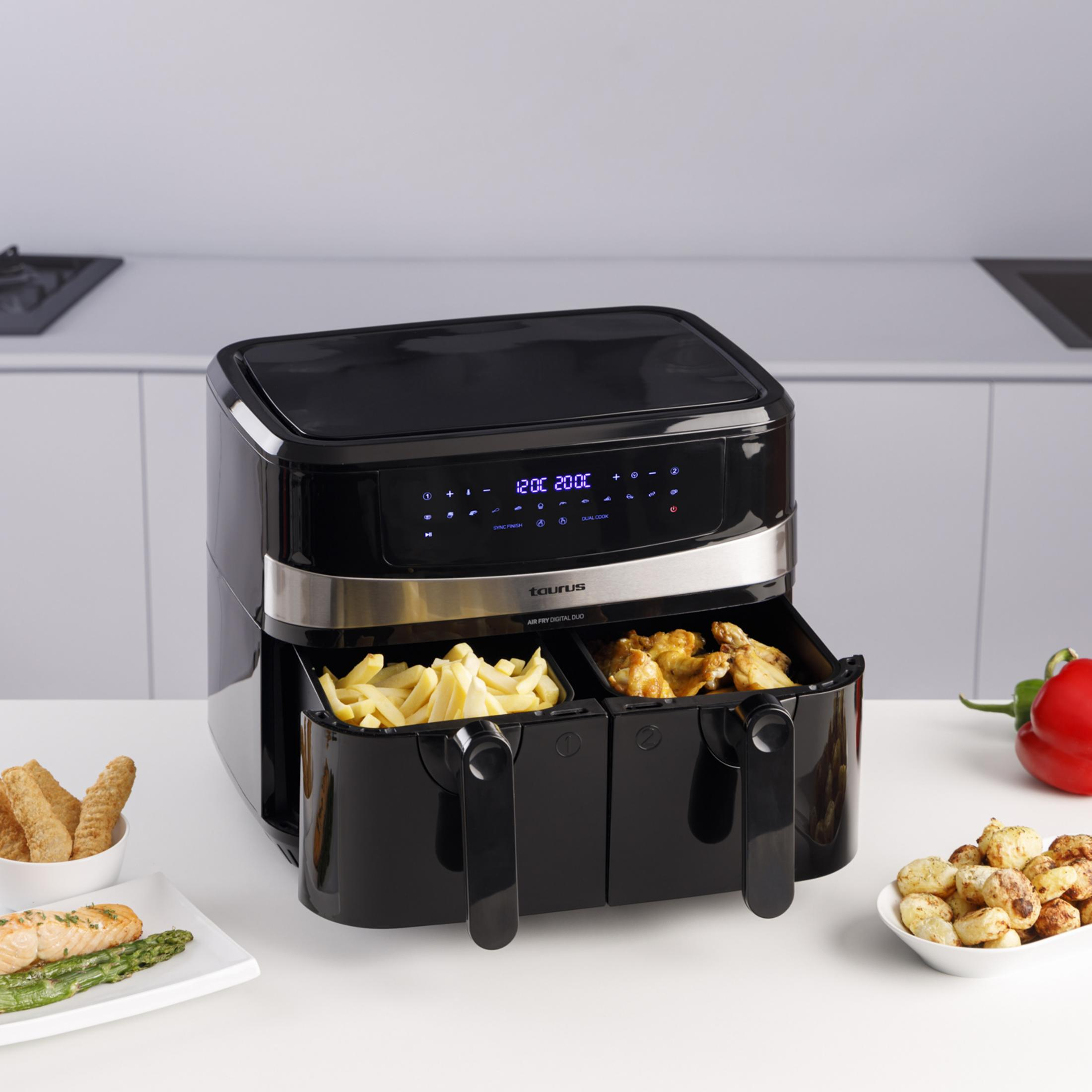 A black dual air fryer with french fries and chicken.