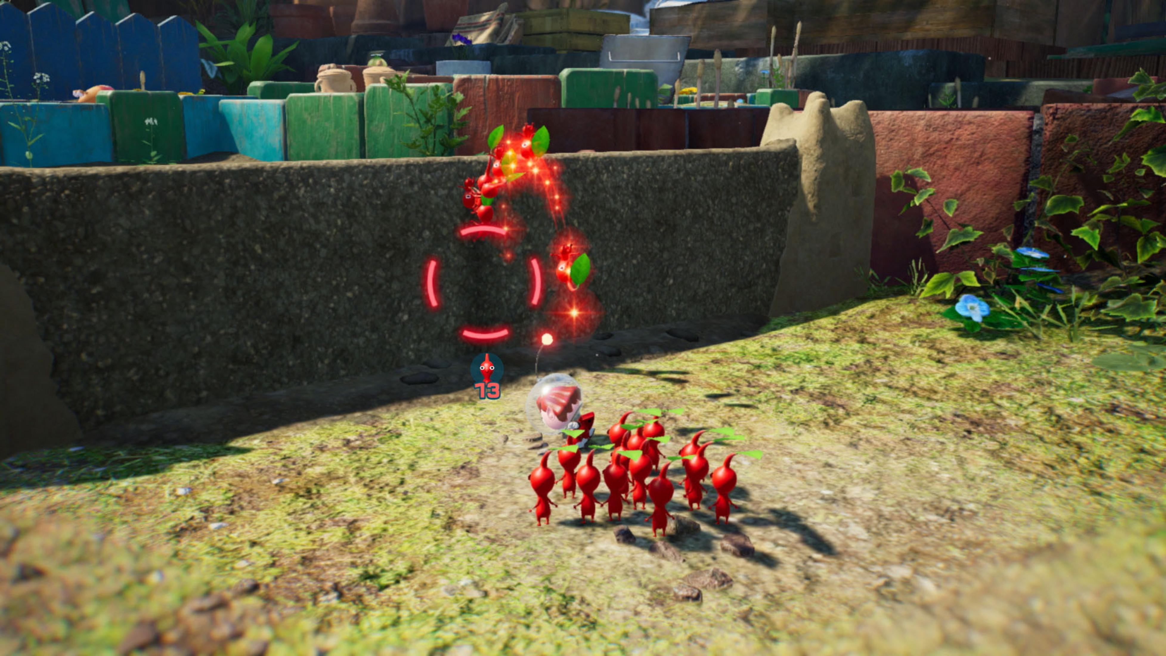 Pikmins rojos siguen a una criatura. Enemigo rojo con efectos brillantes está en la pared.