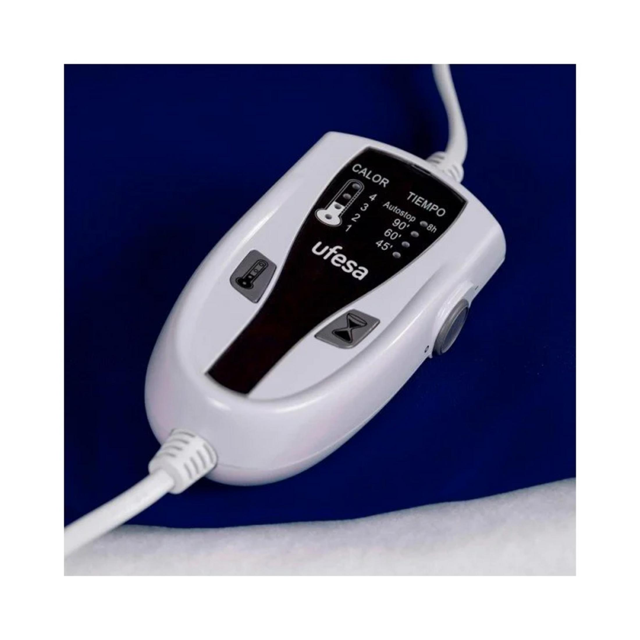 Un controller Ufesa bianco con pulsanti per temperatura e tempo poggia su tessuto blu.