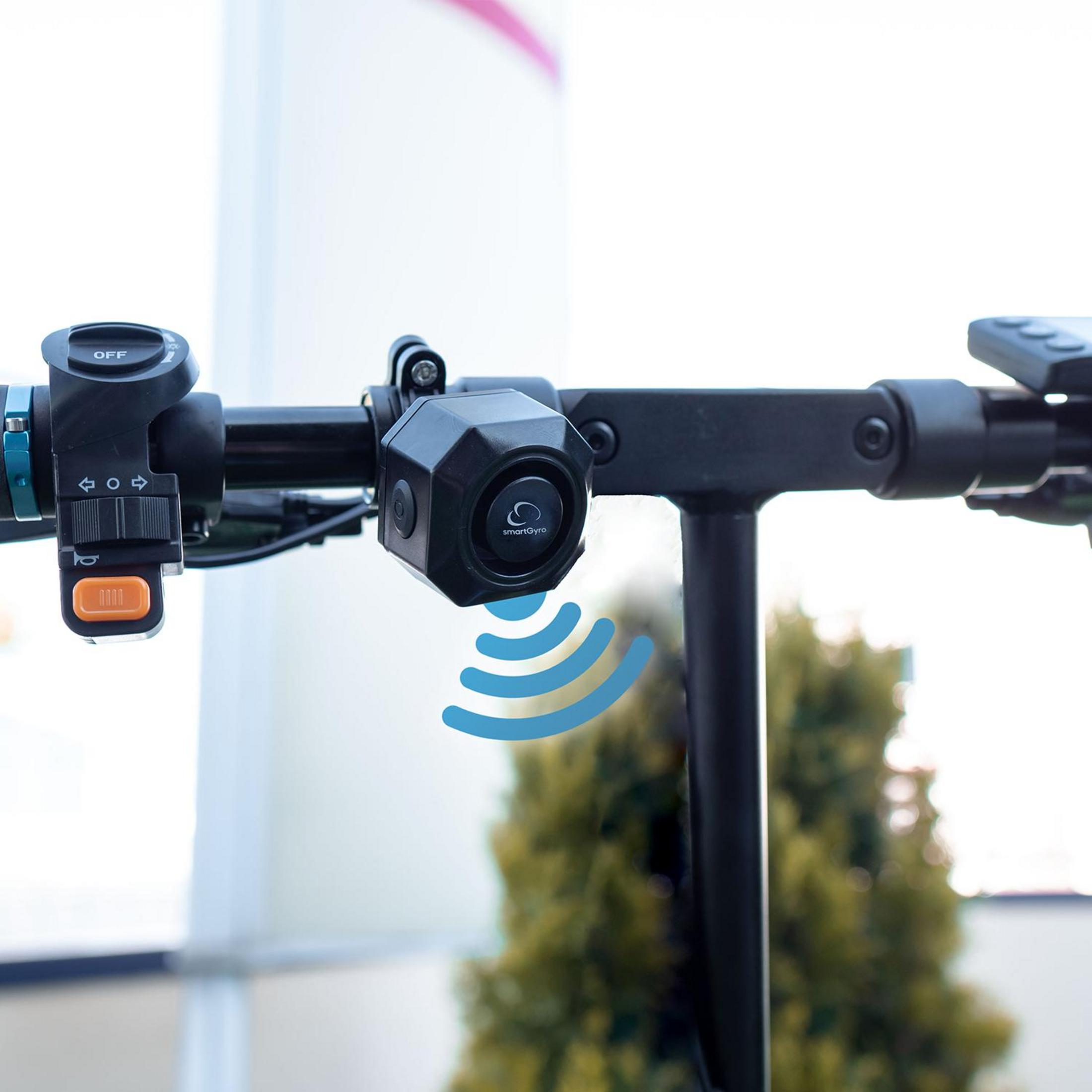 Primer plano del manillar de un patinete eléctrico con controles y altavoz.