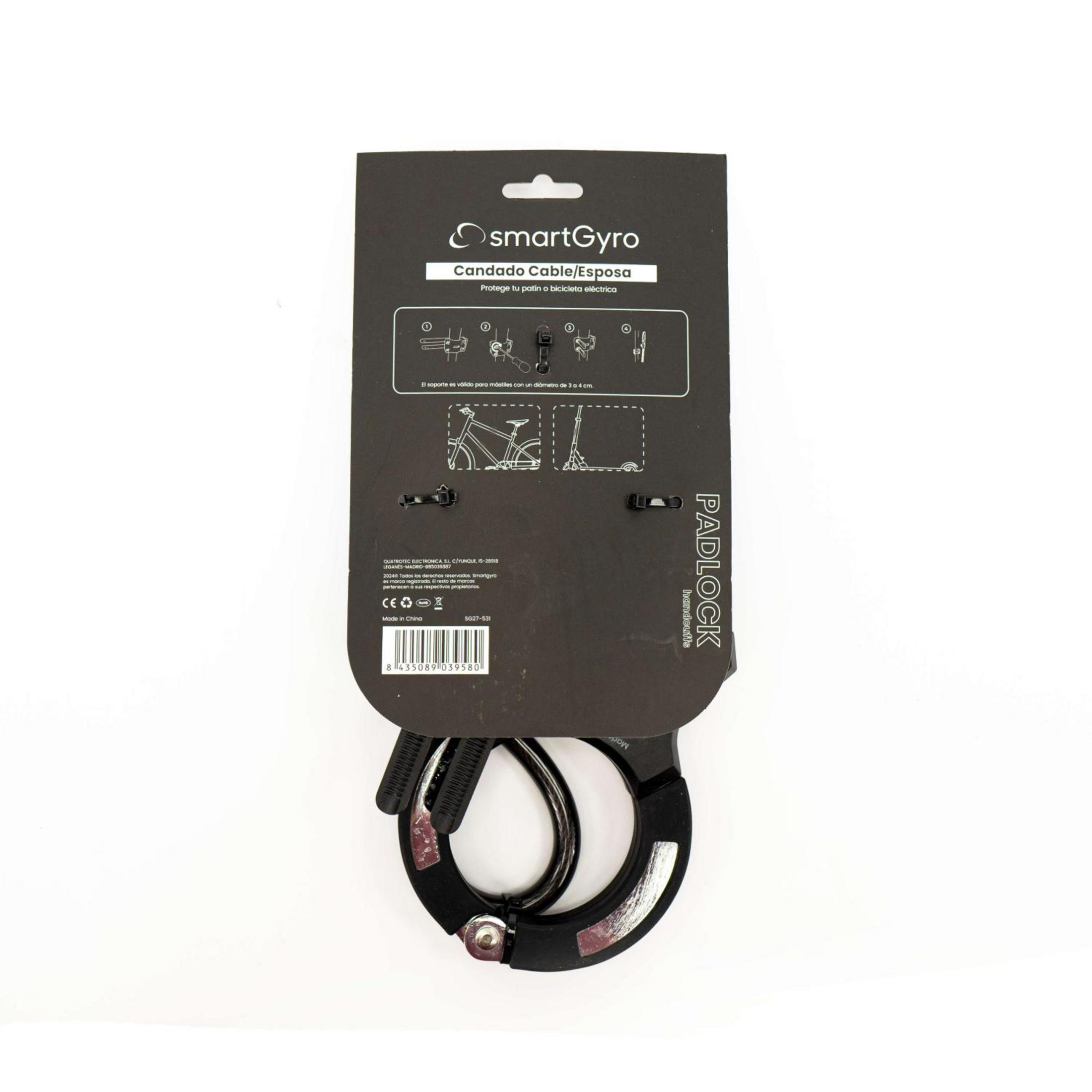Candado negro para bicicleta con cable y detalles plateados en embalaje negro.