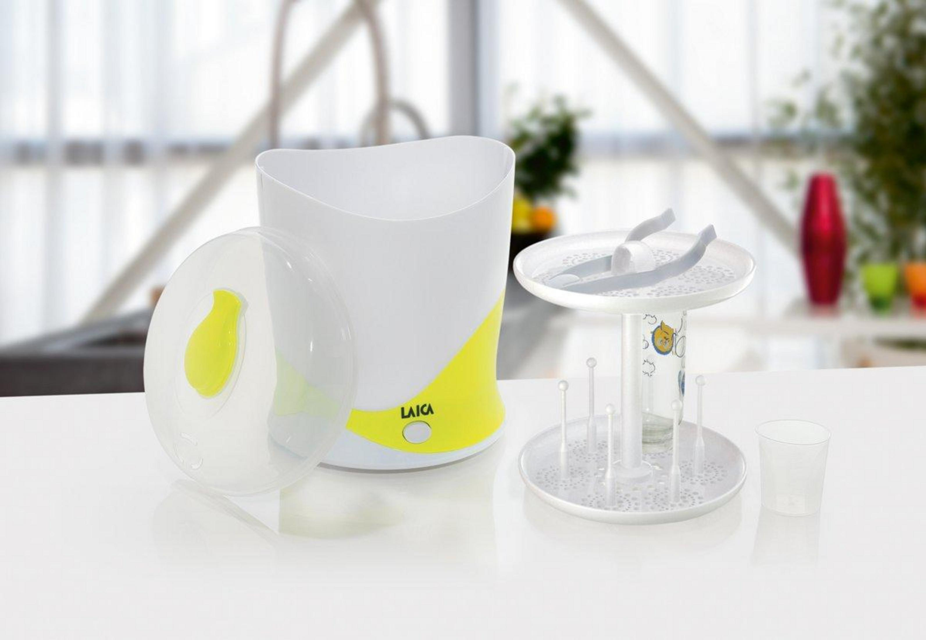 Un esterilizador de vapor blanco con detalles amarillos y accesorios sobre una mesa.
