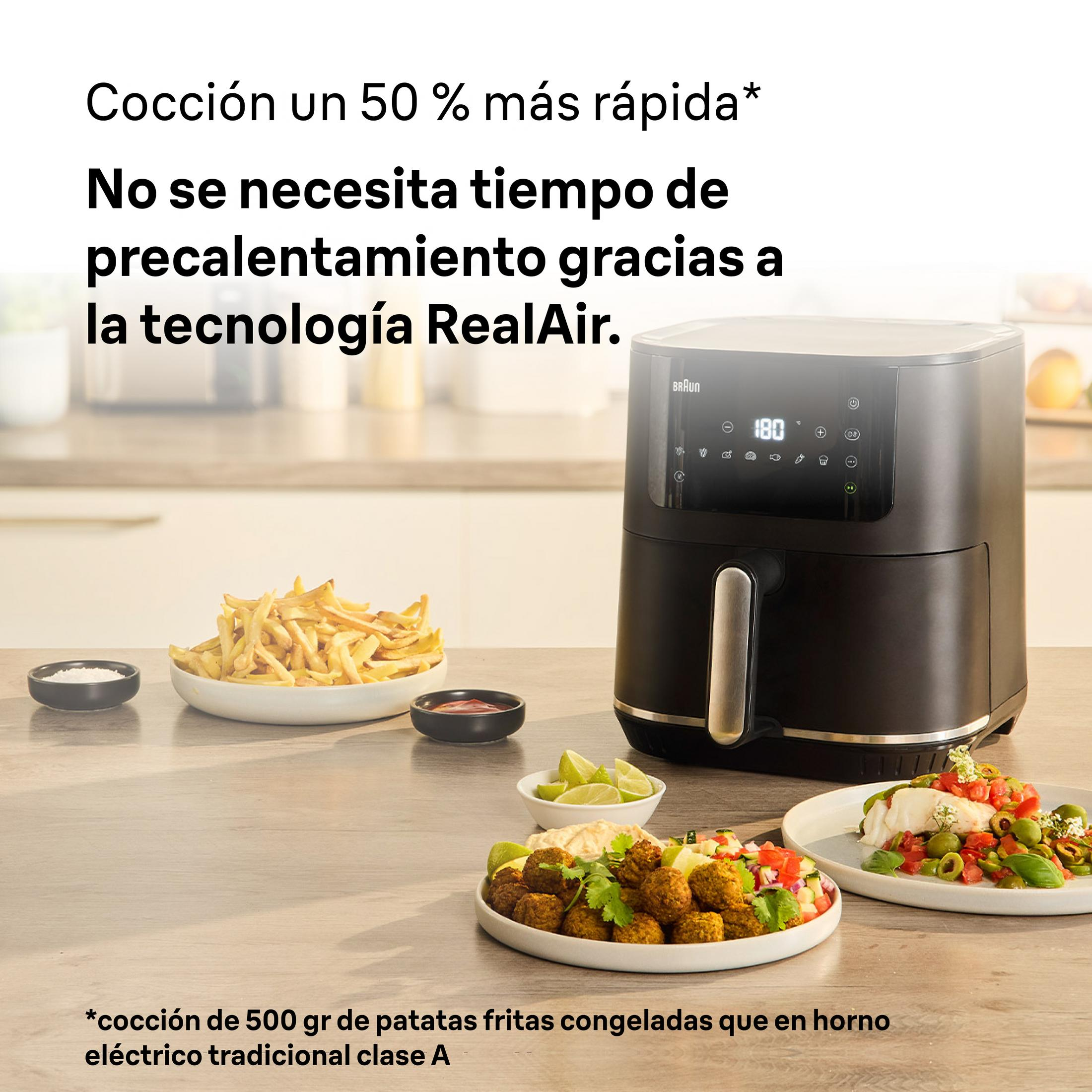 Black air fryer with french fries, falafel, and fish.