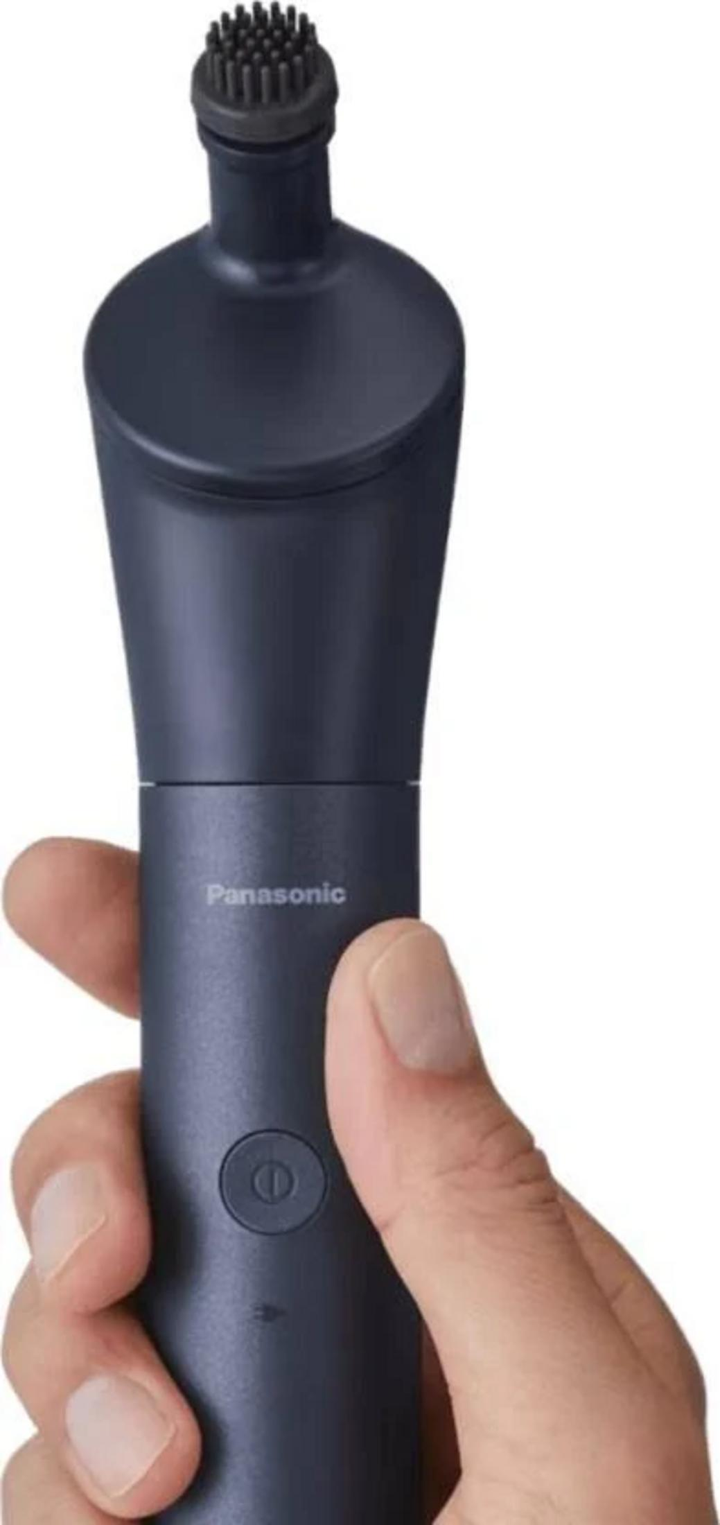 Une tondeuse à barbe Panasonic foncée est tenue dans une main.