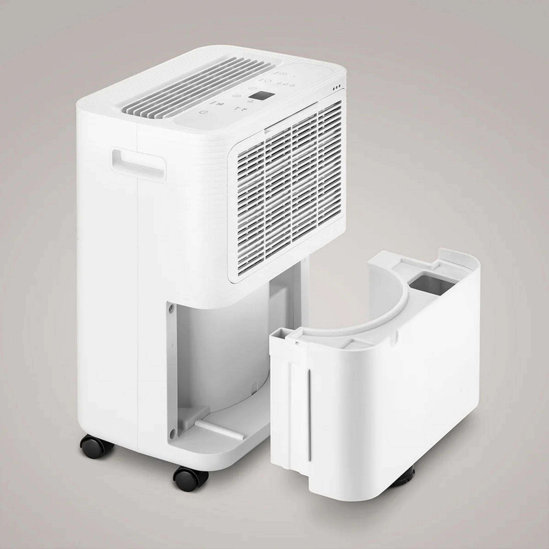 Un deumidificatore bianco con il serbatoio dell'acqua estratto su sfondo grigio.