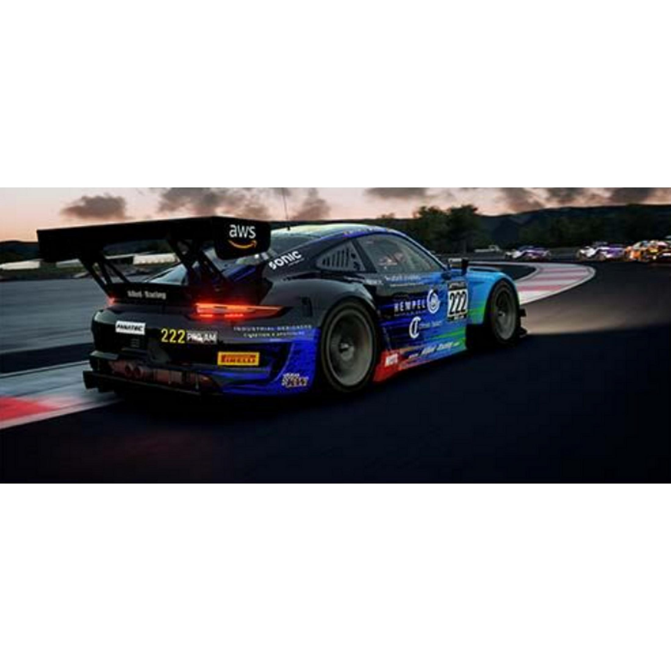 Un coche de carreras azul y negro con el número 222 acelera en una pista al anochecer.