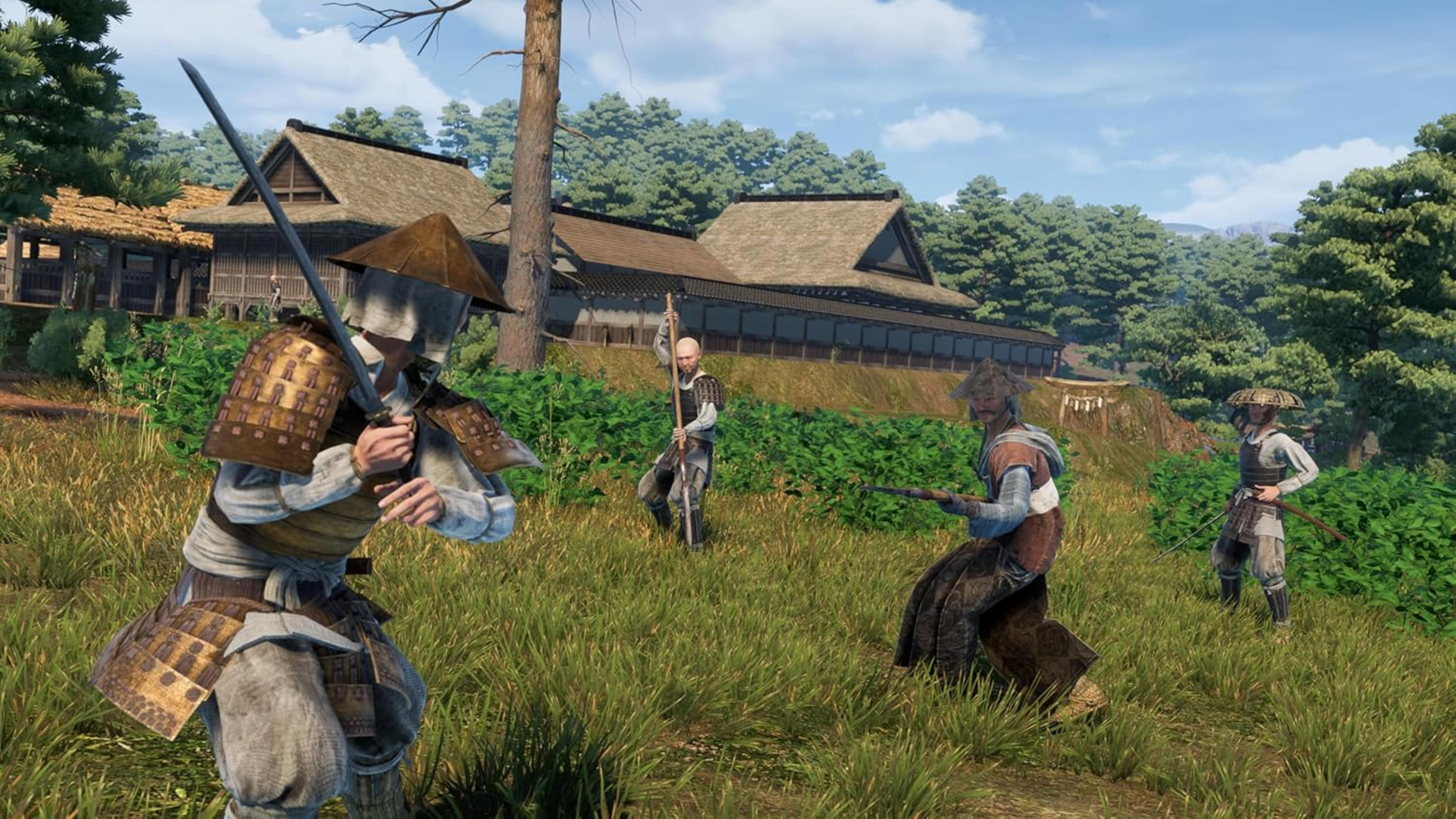 Quattro samurai in abiti tradizionali combattono sull'erba davanti a edifici tradizionali.