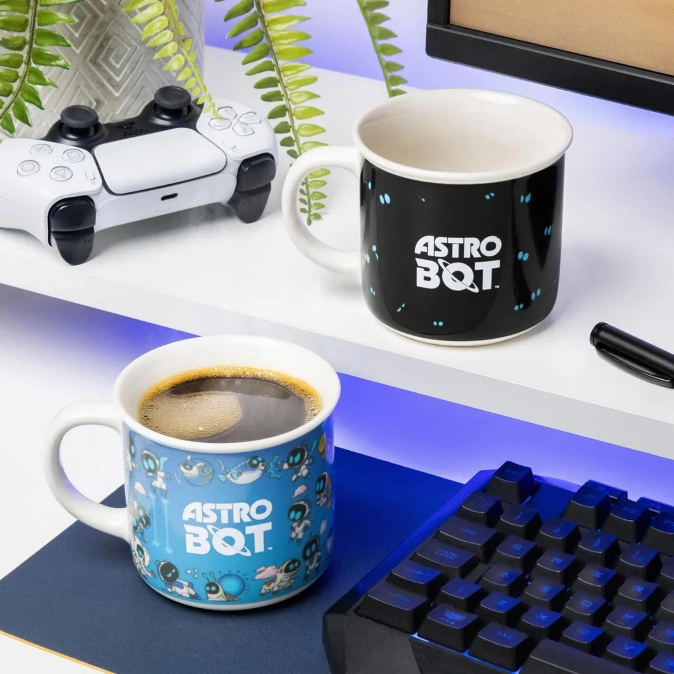 Ein weißer Controller, zwei Astro Bot Tassen und eine Tastatur auf einem Regal.