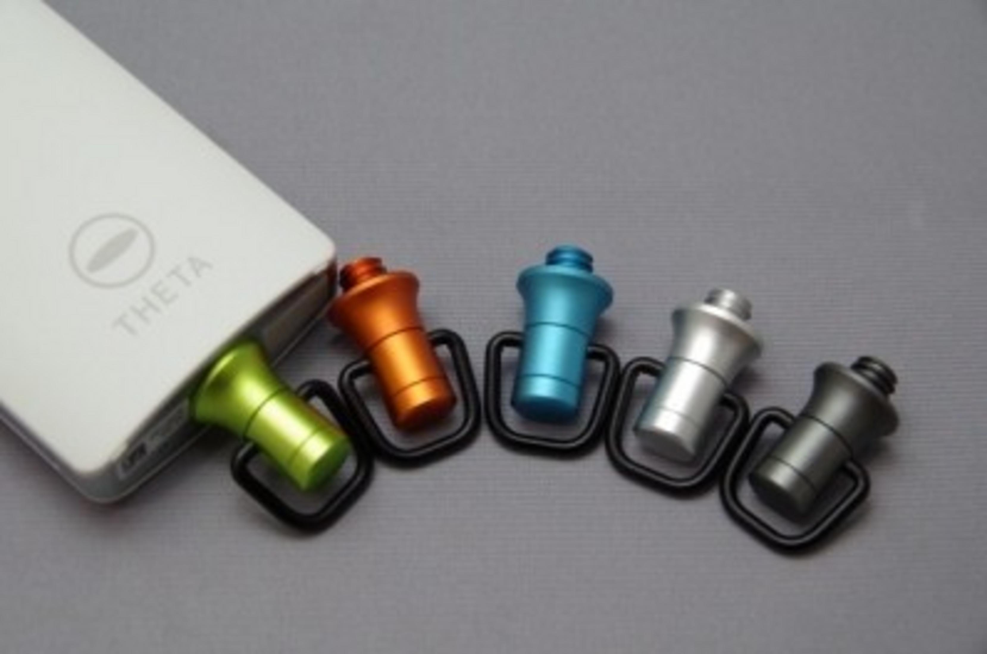 Biały power bank z pięcioma kolorowymi zaczepami: zielonym, pomarańczowym, niebieskim, srebrnym, szarym.