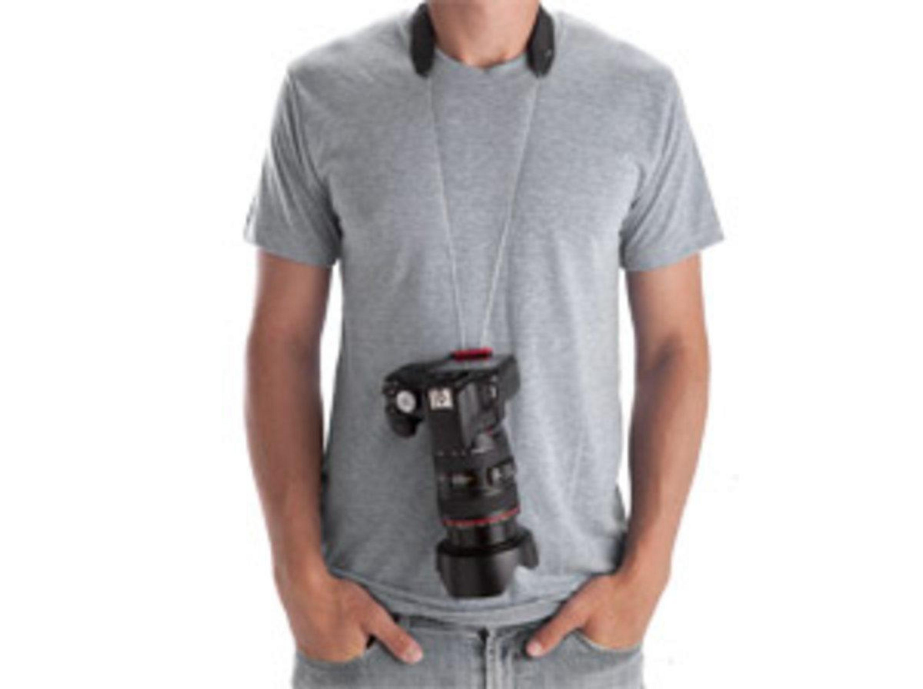 Ein Mann trägt ein graues T-Shirt und eine Kamera um den Hals.
