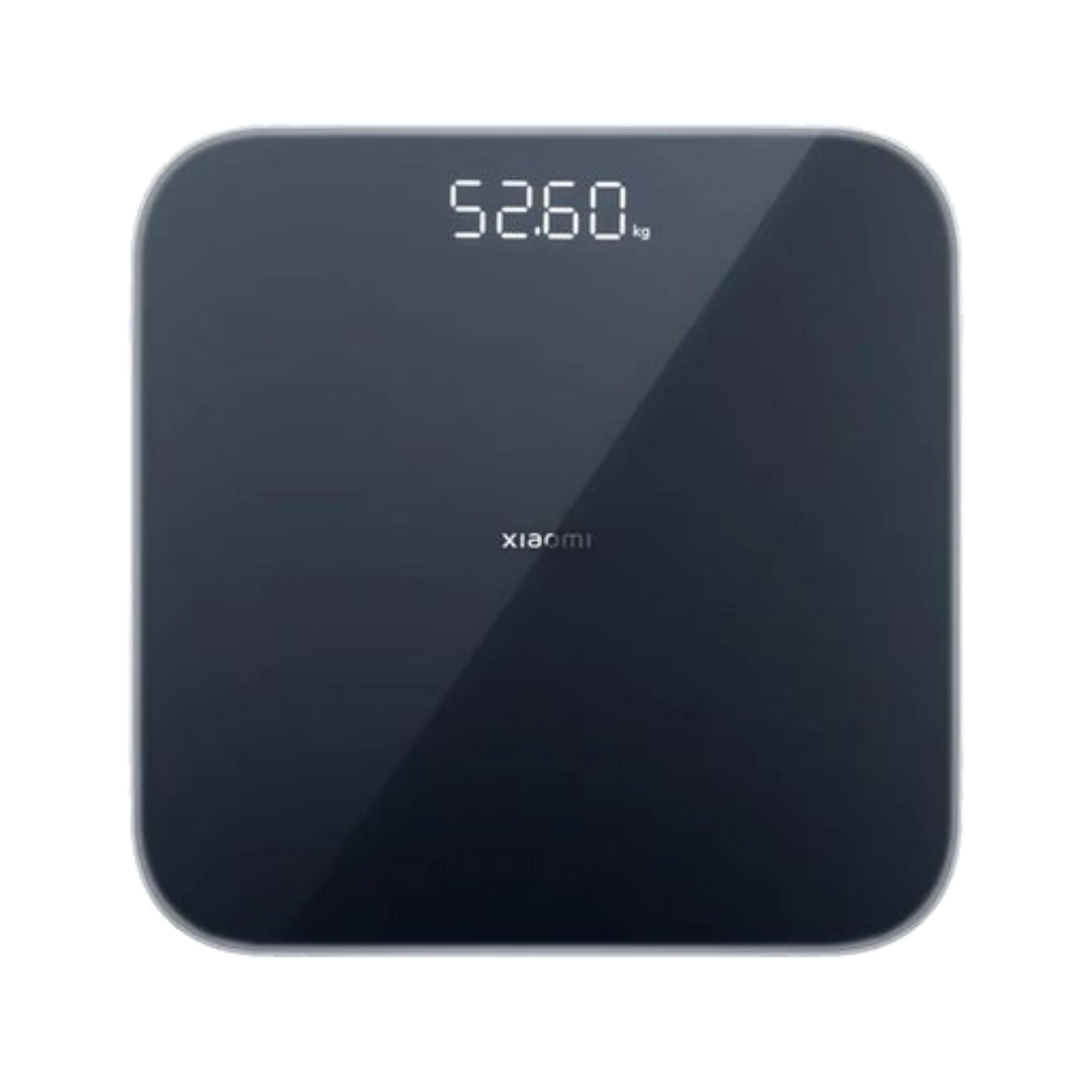 Eine dunkle smarte Waage mit digitaler Anzeige zeigt 52,60 kg.