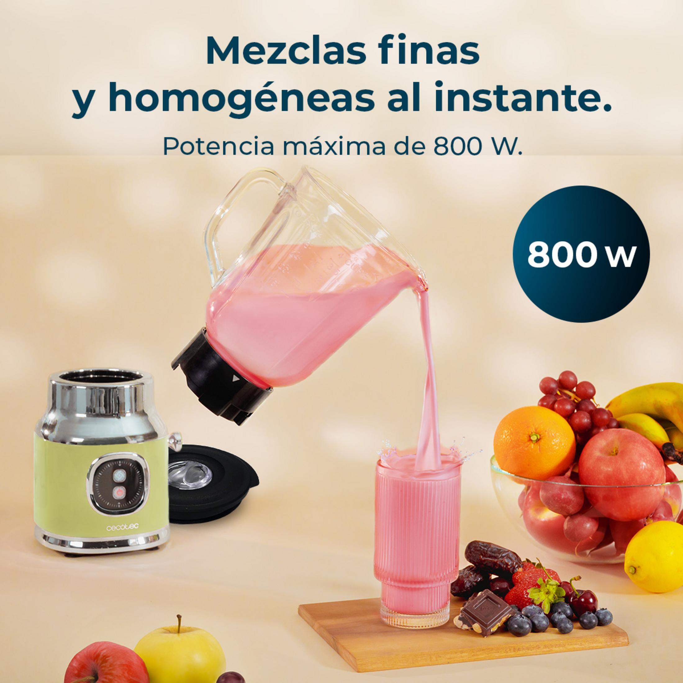 Una batidora de 800W vierte un batido rosa en un vaso. Hay frutas cerca.